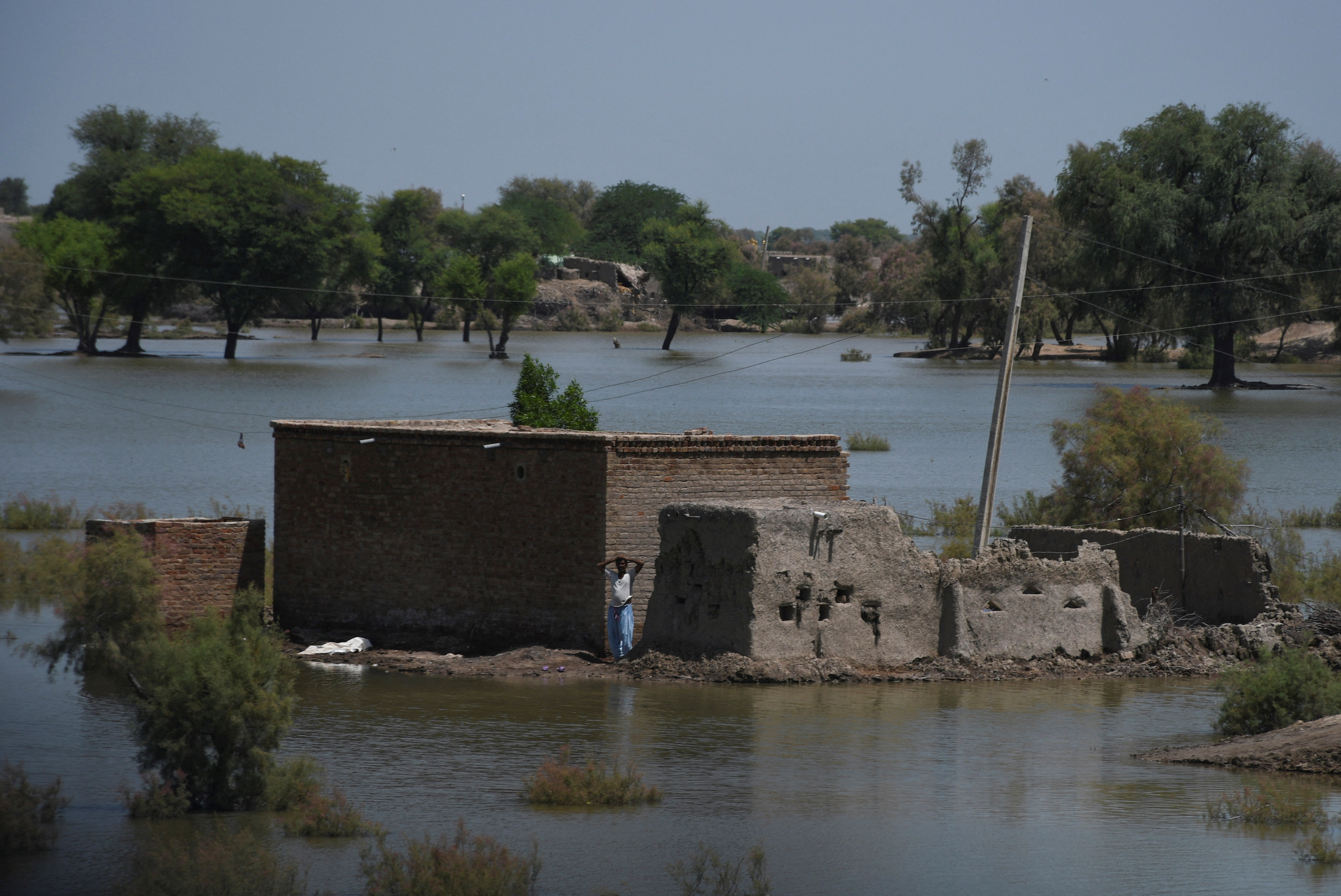A man stands outside his damaged home in Khairpur Nathan Shah in Pakistan’s Sindh province