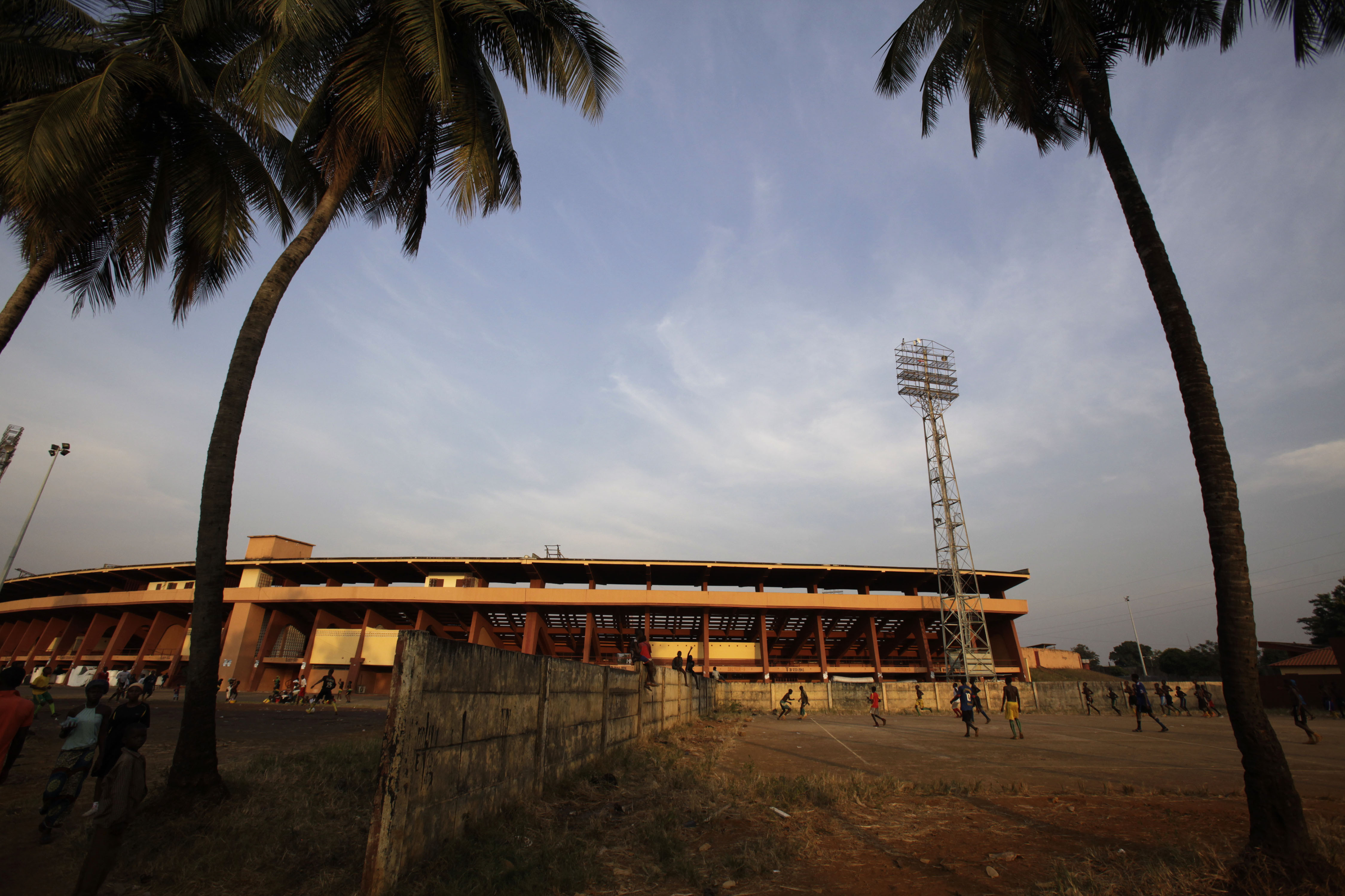 FILE - In this Friday, Dec. 11, 2009 file photo, young soccer players train outside the September 28 stadium in Conakry, Guinea. On Sept. 28, 2009 several hundred soldiers stormed the national stadium where an anti-government rally was being held, killing more than 150 people and at least 109 victims of sexual assault in what was an ordered and methodical attack on protesters demanding the resignation of coup leader Moussa “Dadis” Camara. (AP Photo/Rebecca Blackwell, File)