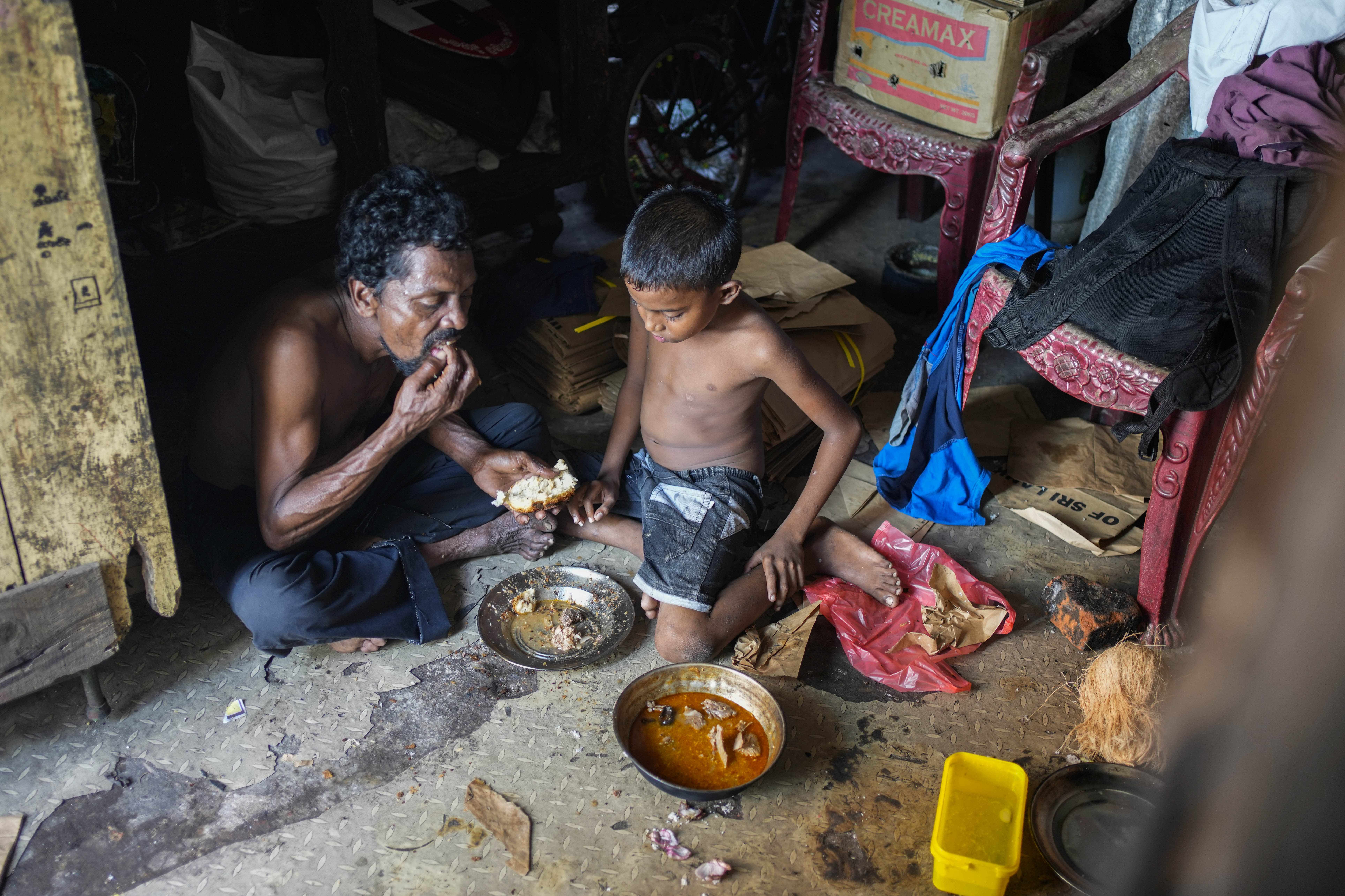 A father and son share a meal at their shanty in Colombo