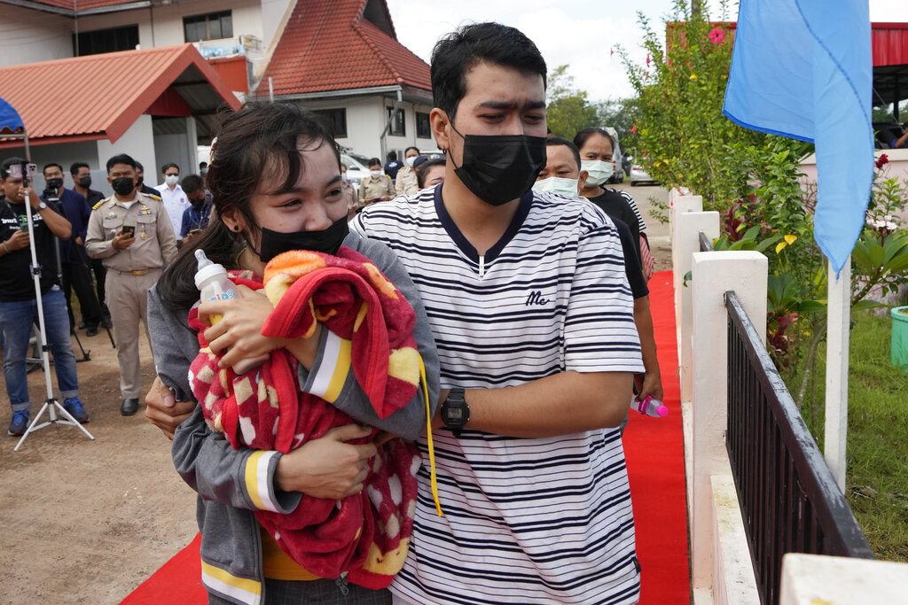 A family of a victim mourns as they carry a blanket and a milk bottle during a ceremony for those killed in the attack on the Young Children's Development Center in the rural town of Uthai Sawan, north eastern Thailand, Friday, Oct. 7, 2022. A former policeman facing a drug charge burst into a day care center in northeastern Thailand on Thursday, killing dozens of preschoolers and teachers before shooting more people as he fled in the deadliest rampage in the nation's history. (AP Photo/Sakchai Lalit)