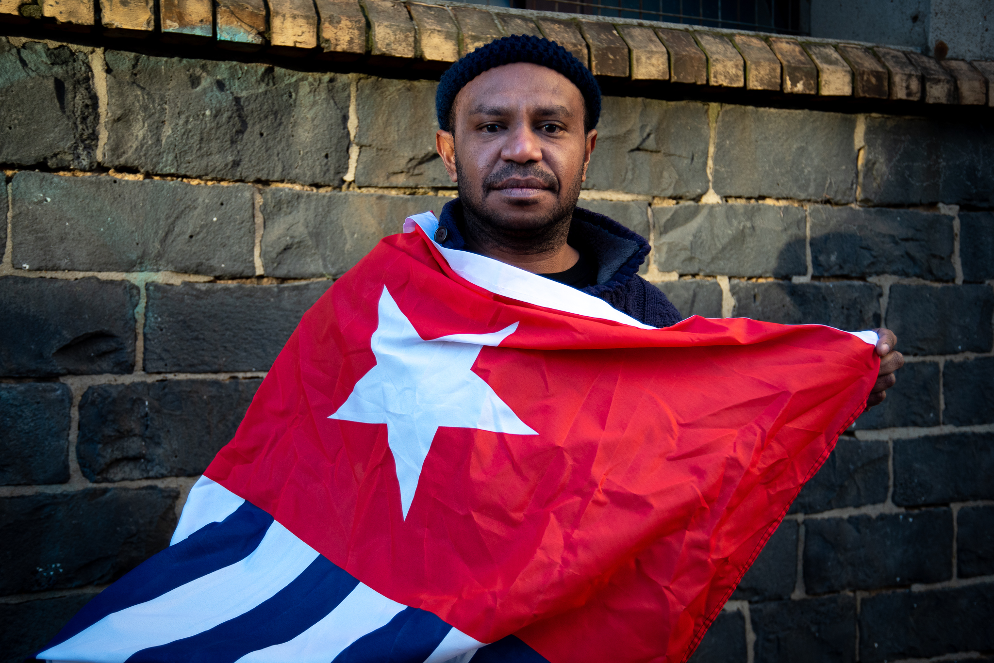Adolf Mora wraps the Morning Star flag of West Papuan independence around his shoulders. Mora was one of 43 West Papuans who arrived in Australia in 2006 and were allowed to stay