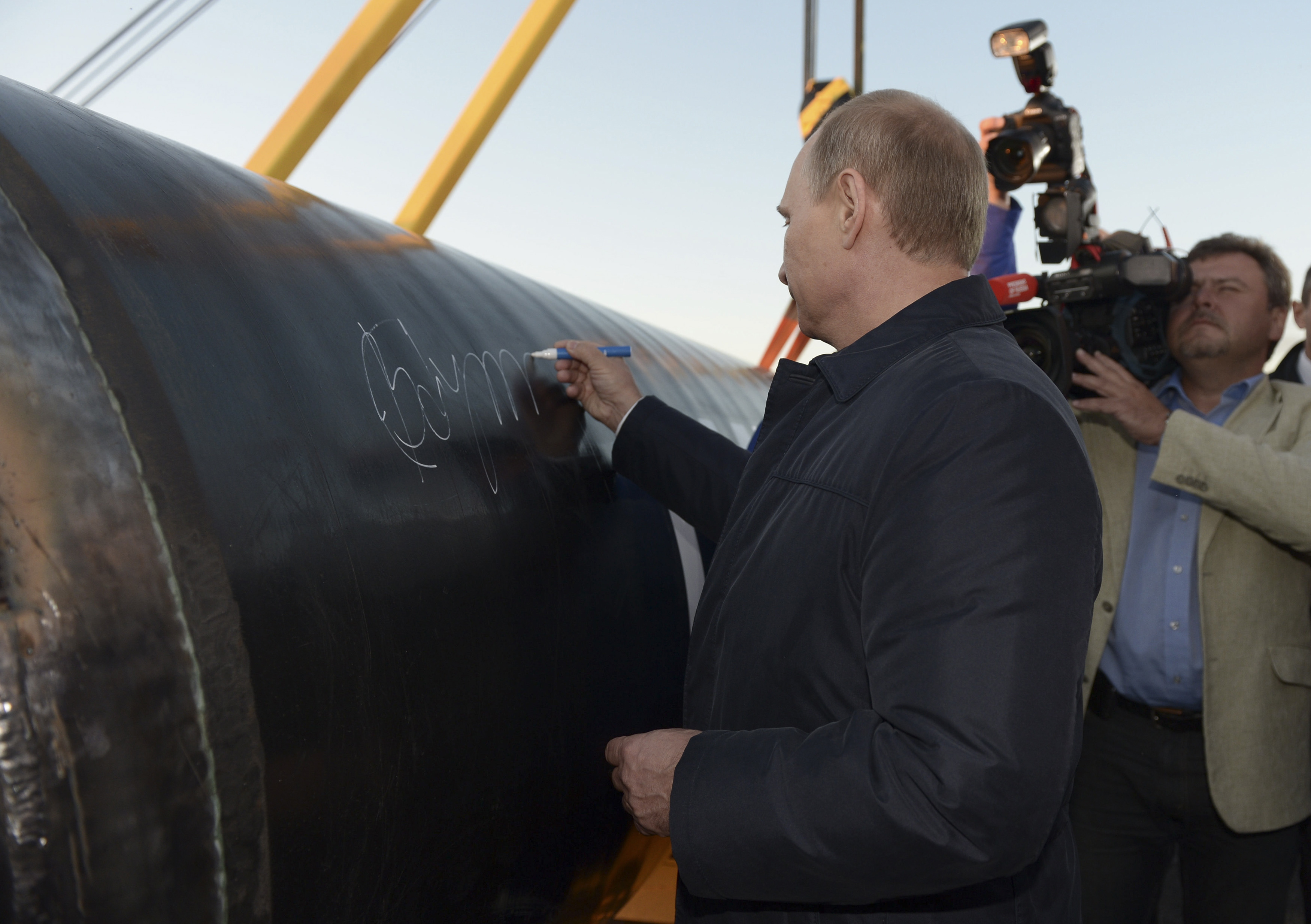 Russia's President Vladimir Putin signs on the first segment of pipeline during a ceremony marking the start of construction of "Power of Siberia" pipeline at the village of Us Khatyn, September 1, 2014. President Vladimir Putin on Monday oversaw the start of construction on a giant pipeline that is due to ship $400 billion worth of Russian gas to China in the three decades after flows begin in 2019. REUTERS/Alexei Nikolsky/RIA Novosti/Kremlin (RUSSIA - Tags: BUSINESS POLITICS ENERGY TPX IMAGES OF THE DAY) THIS IMAGE HAS BEEN SUPPLIED BY A THIRD PARTY. IT IS DISTRIBUTED, EXACTLY AS RECEIVED BY REUTERS, AS A SERVICE TO CLIENTS
