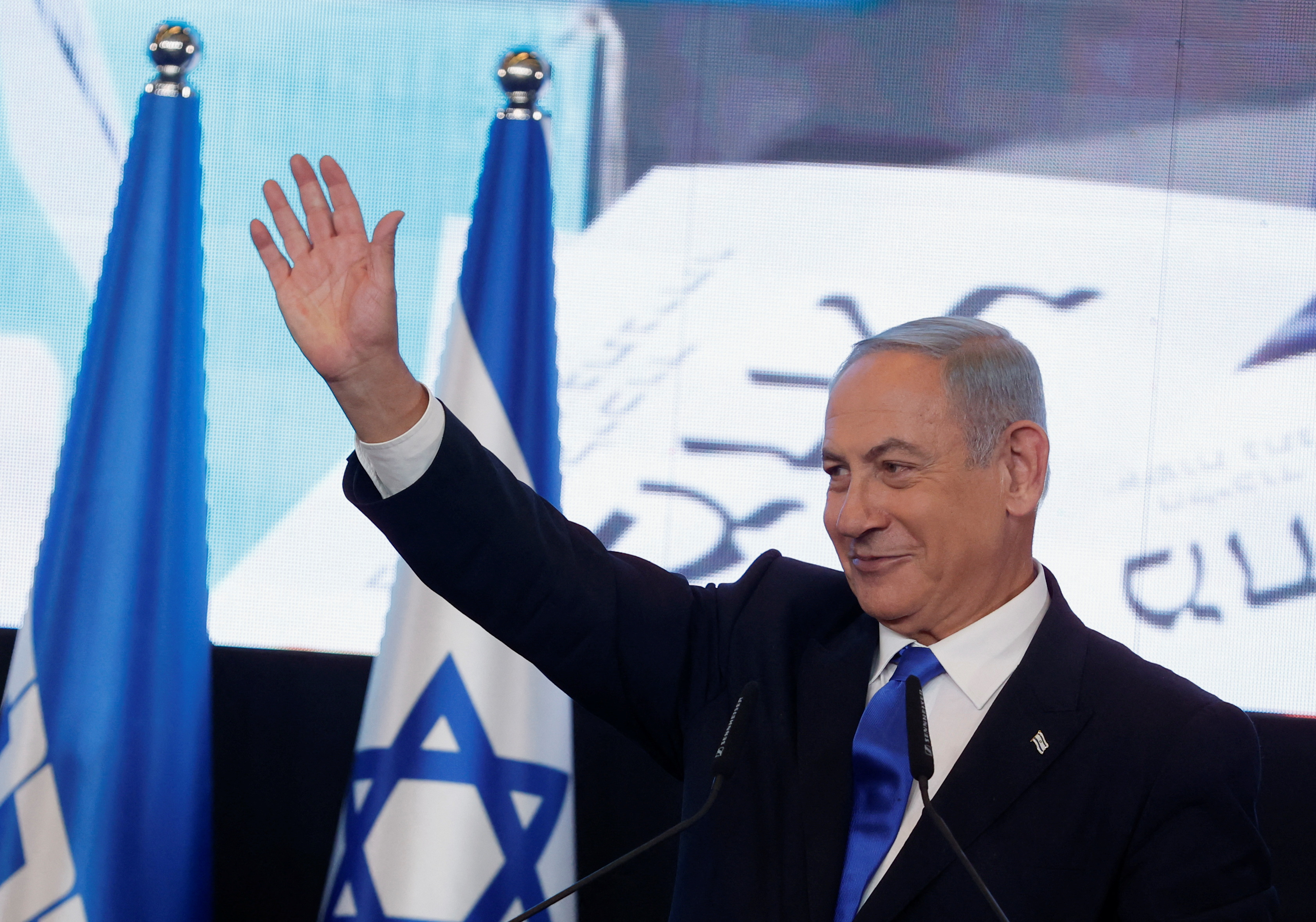 Benjamin Netanyahu waves as he addresses his supporters at his party headquarters