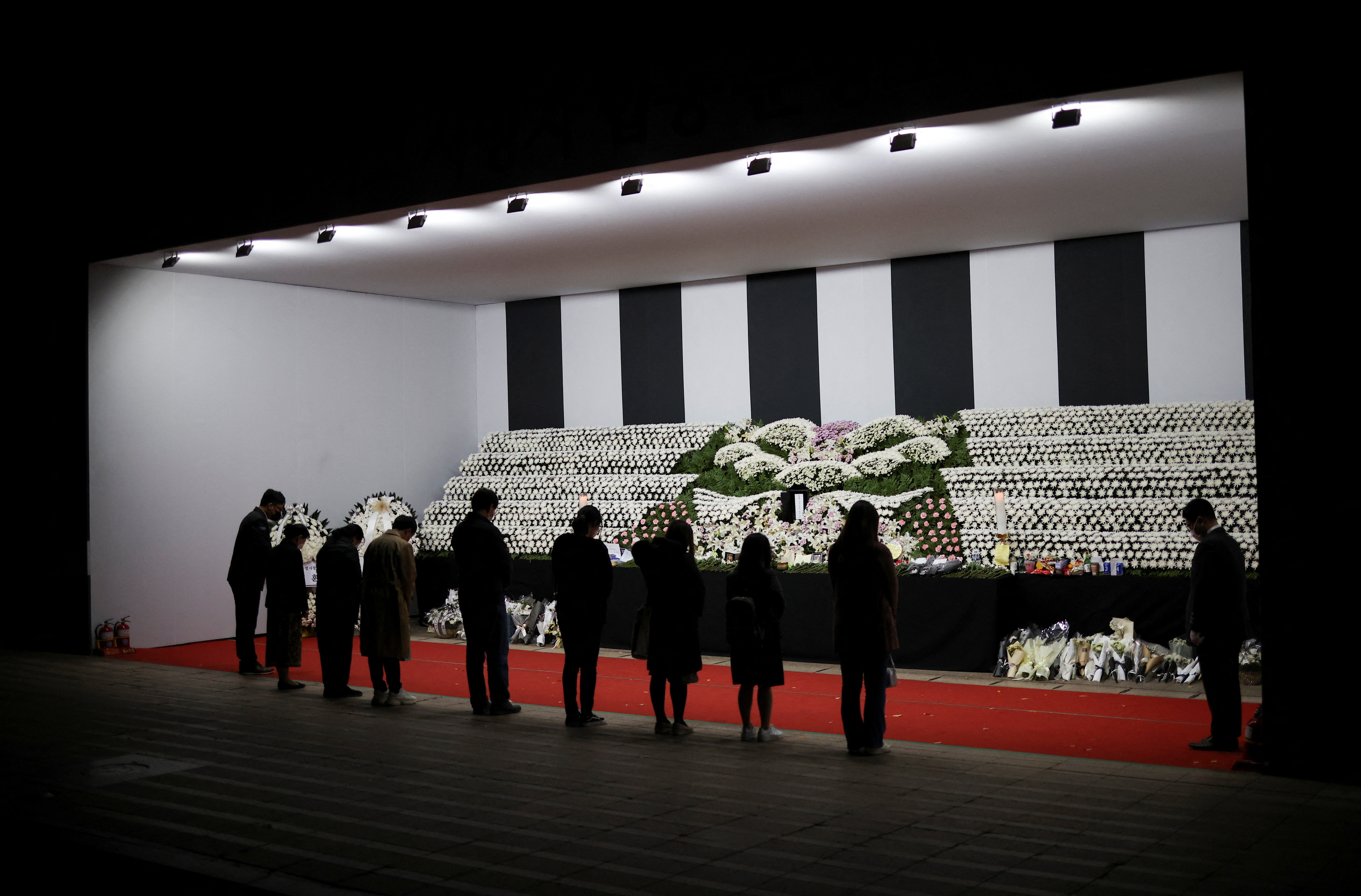 People mourn at a group memorial