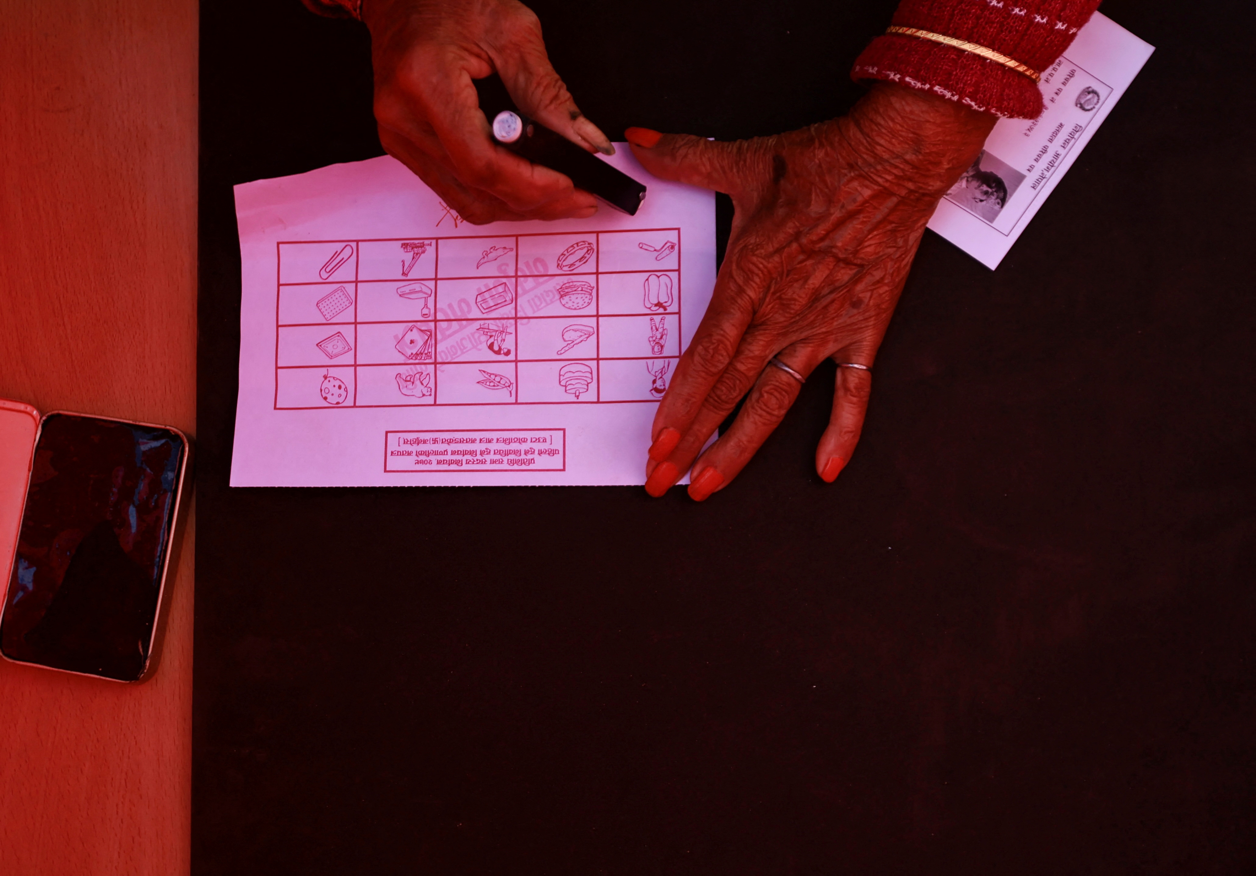 A woman casts a vote during a mock election, held to familiarize people with the electoral process ahead of the general elections, in Lalitpur, Nepal