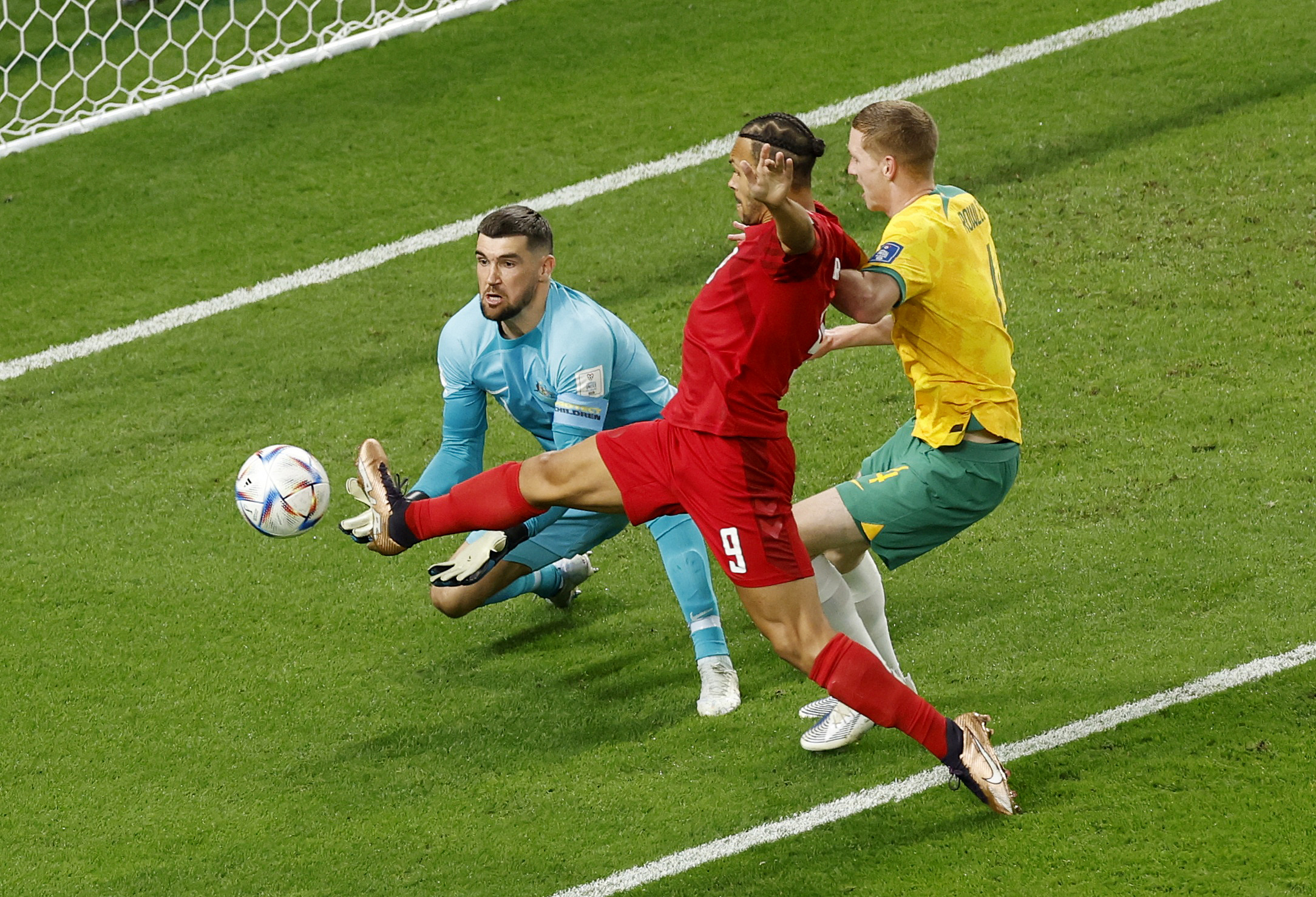 Denmark's Martin Braithwaite in action with Australia's Mathew Ryan and Kye Rowles