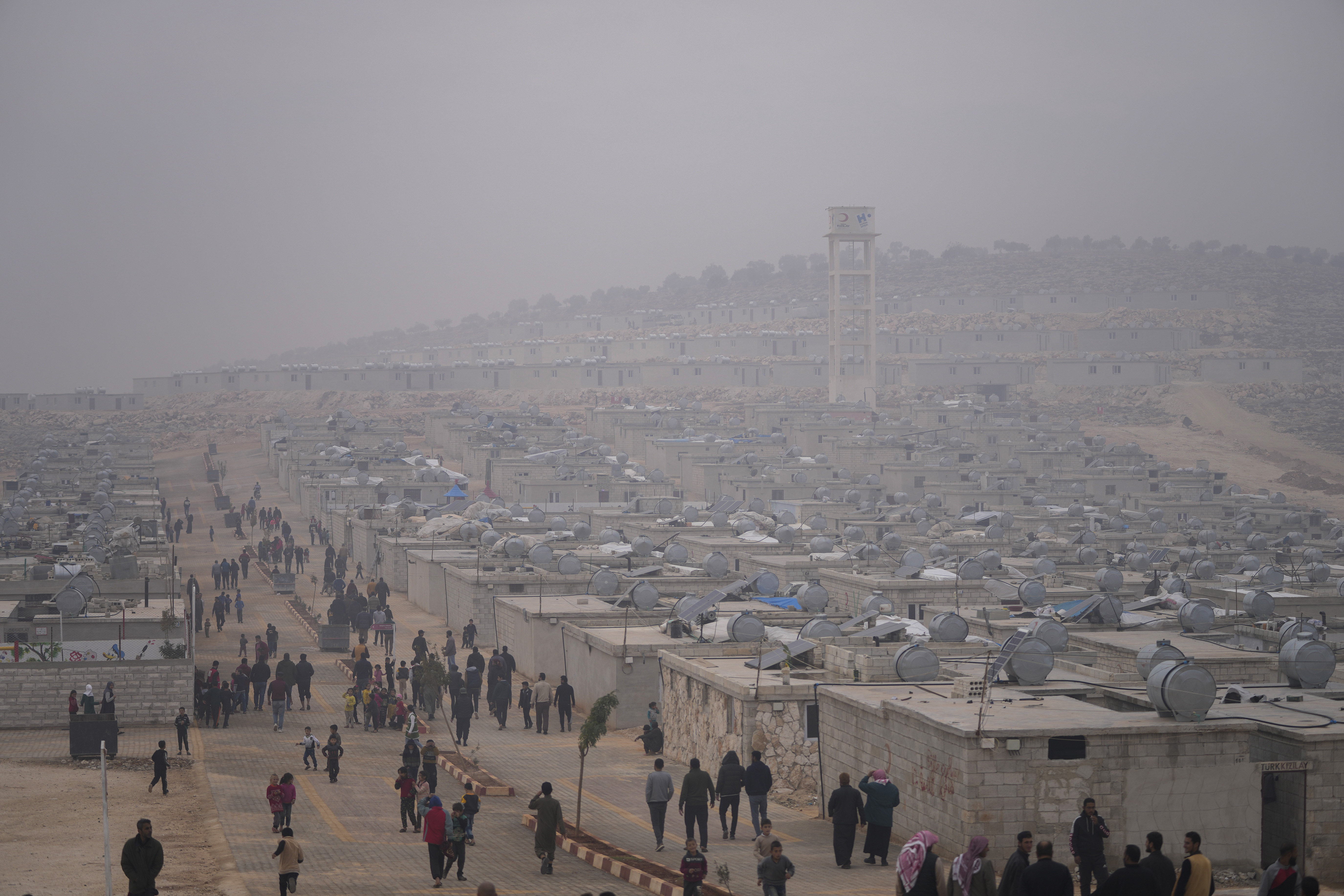 Syrians walk along in a refugee camp for displaced people run by the Turkish Red Crescent in Sarmada district, north of Idlib city, Syria, Nov. 26, 2021