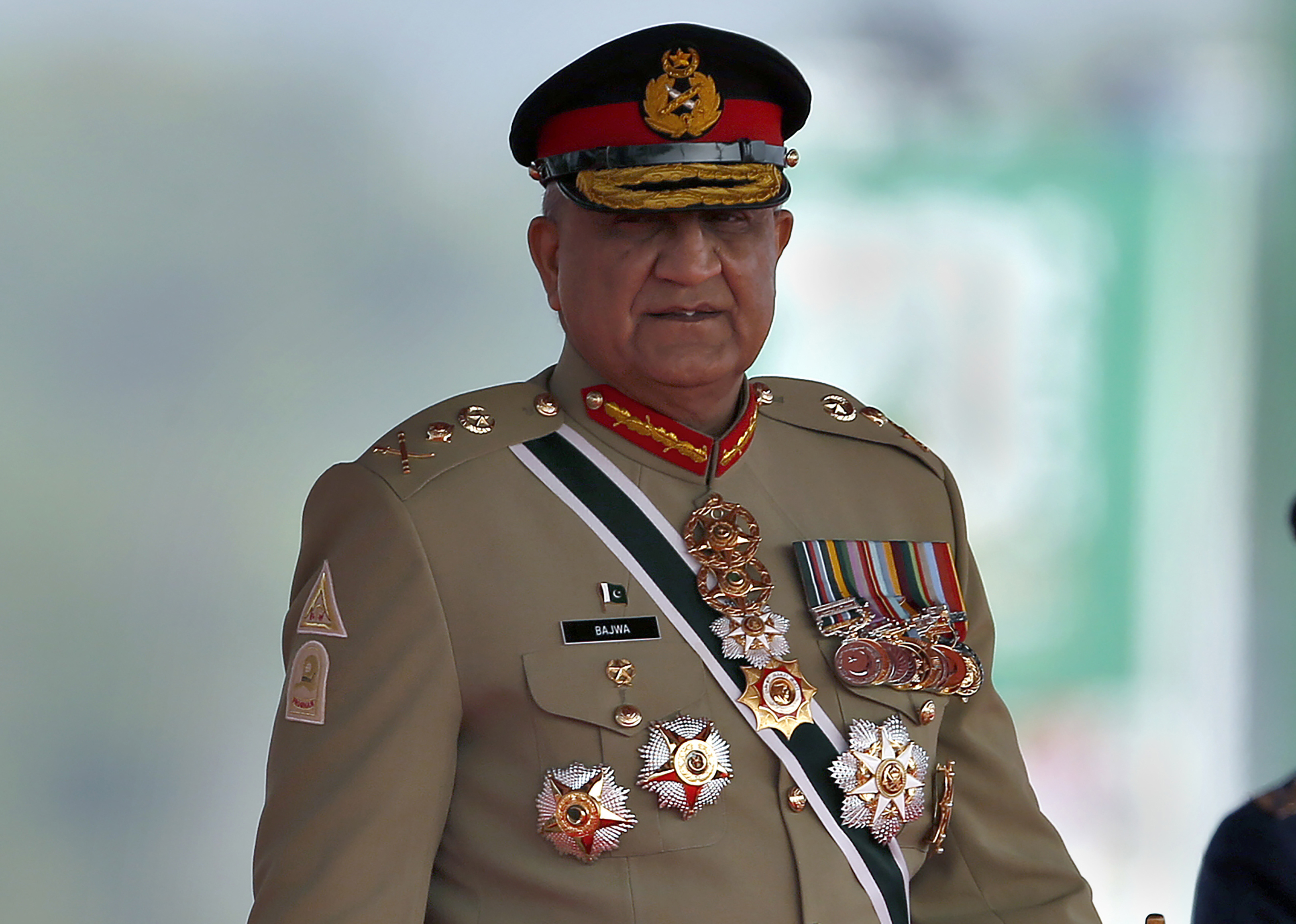 FILE - Pakistan's Army Chief General Qamar Javed Bajwa arrive to attend a military parade to mark Pakistan National Day in Islamabad, Pakistan, Wednesday, March 23, 2022. Officials say Pakistan’s powerful army chief in a rare move this week, Saturday, July 30, contacted Washington, urging U.S. authorities to use their influence to secure an early release of a key $1.7 billion installment from the International Monetary Fund. The latest development comes as Islamabad struggles to stave off a deepening economic crisis. (AP Photo/Anjum Naveed, File)