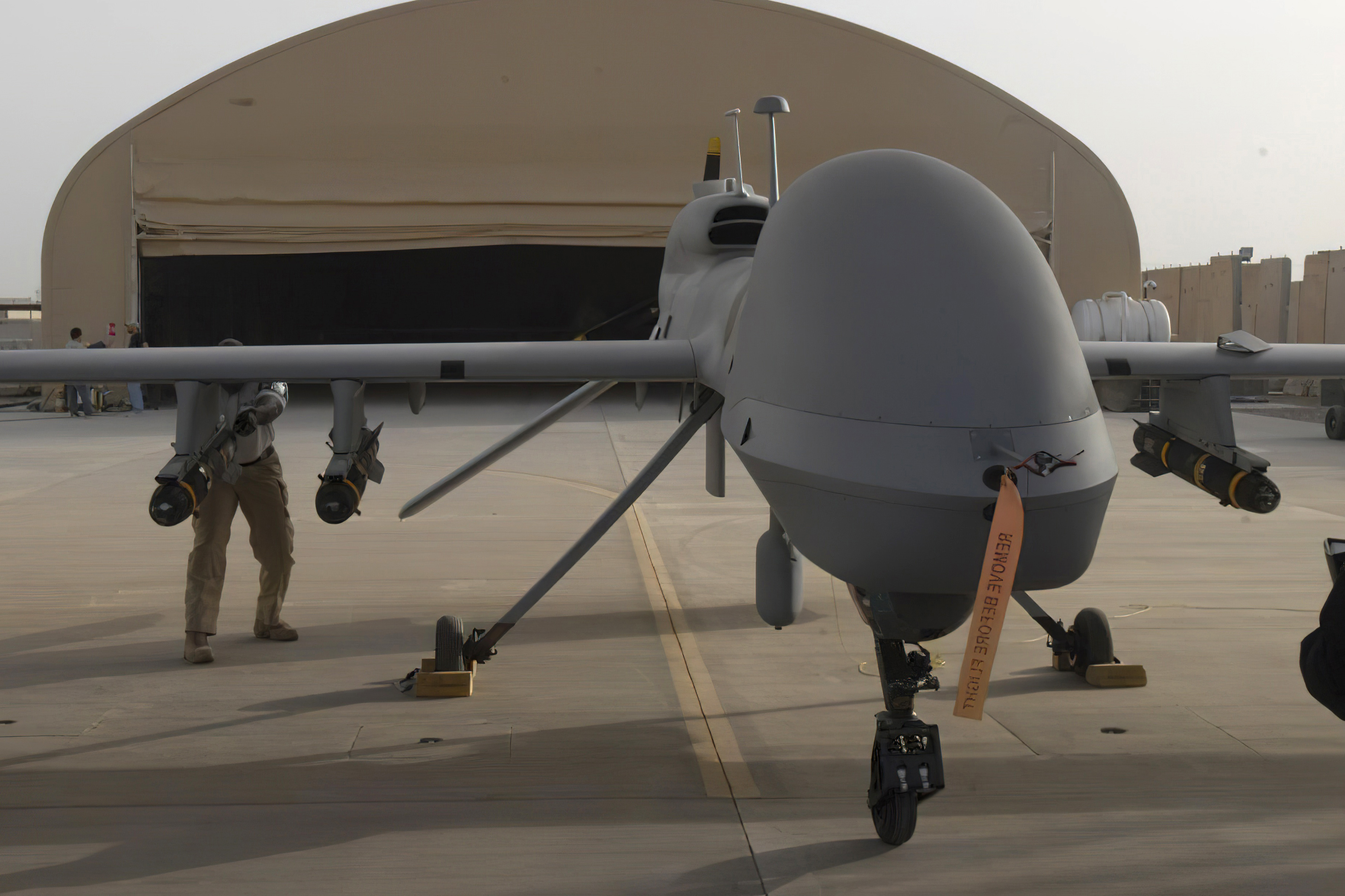 In this image provided by the US Army, contractors from General Atomics load Hellfire missiles onto an MQ-1C Gray Eagle drone.
