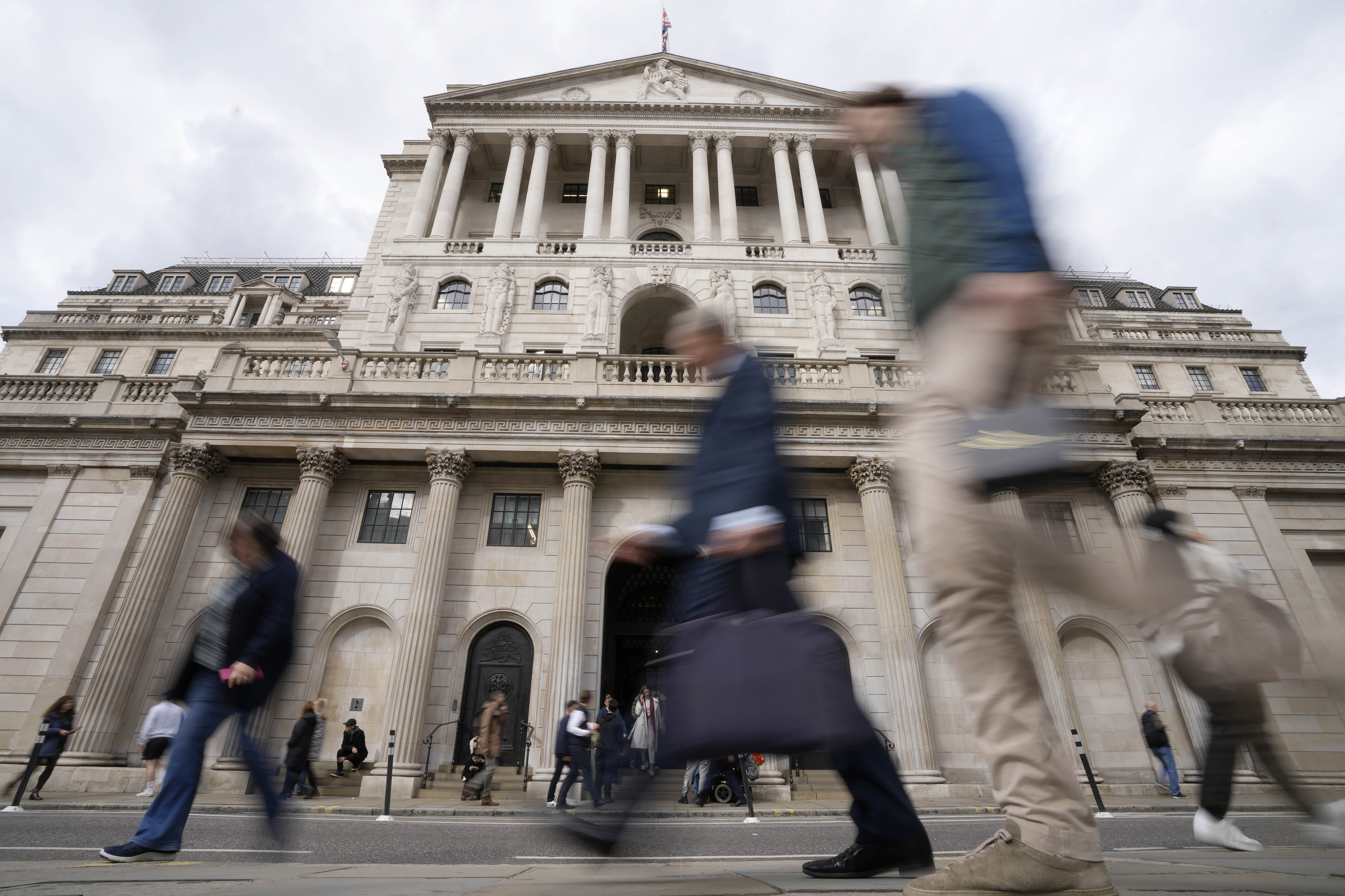 People pass the Bank of England in London