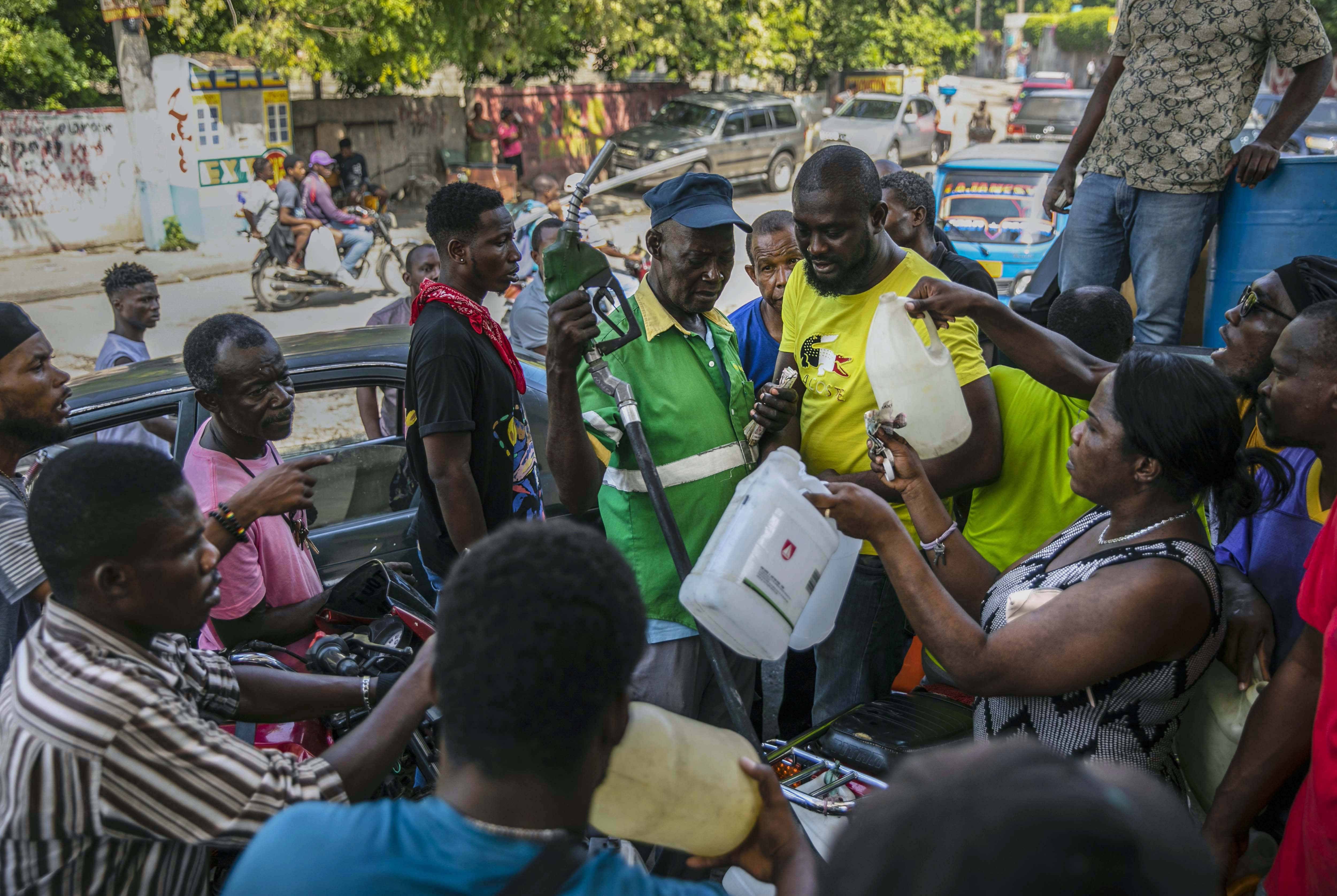People crowd around a gas pump as they try to get their gas tanks filled in Port-au-Prince, Haiti, November 12, 2022