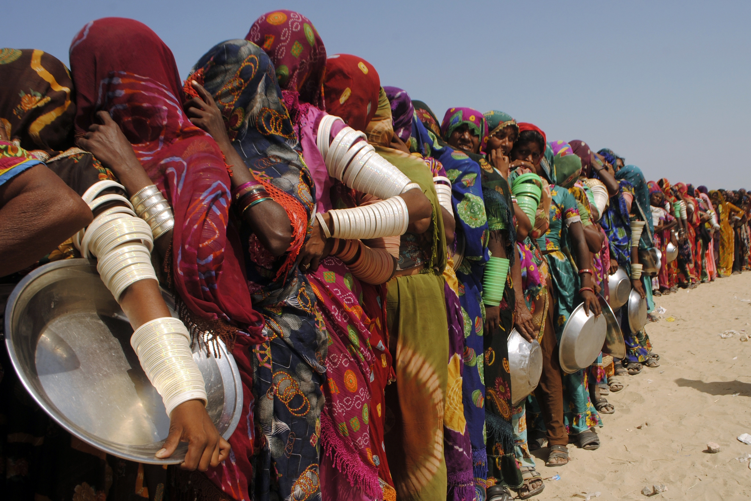 Women from flood-affected areas wait to get free food distributed by a charity, in Chachro, near Tharparkar, a district of southern Sindh province, Pakistan