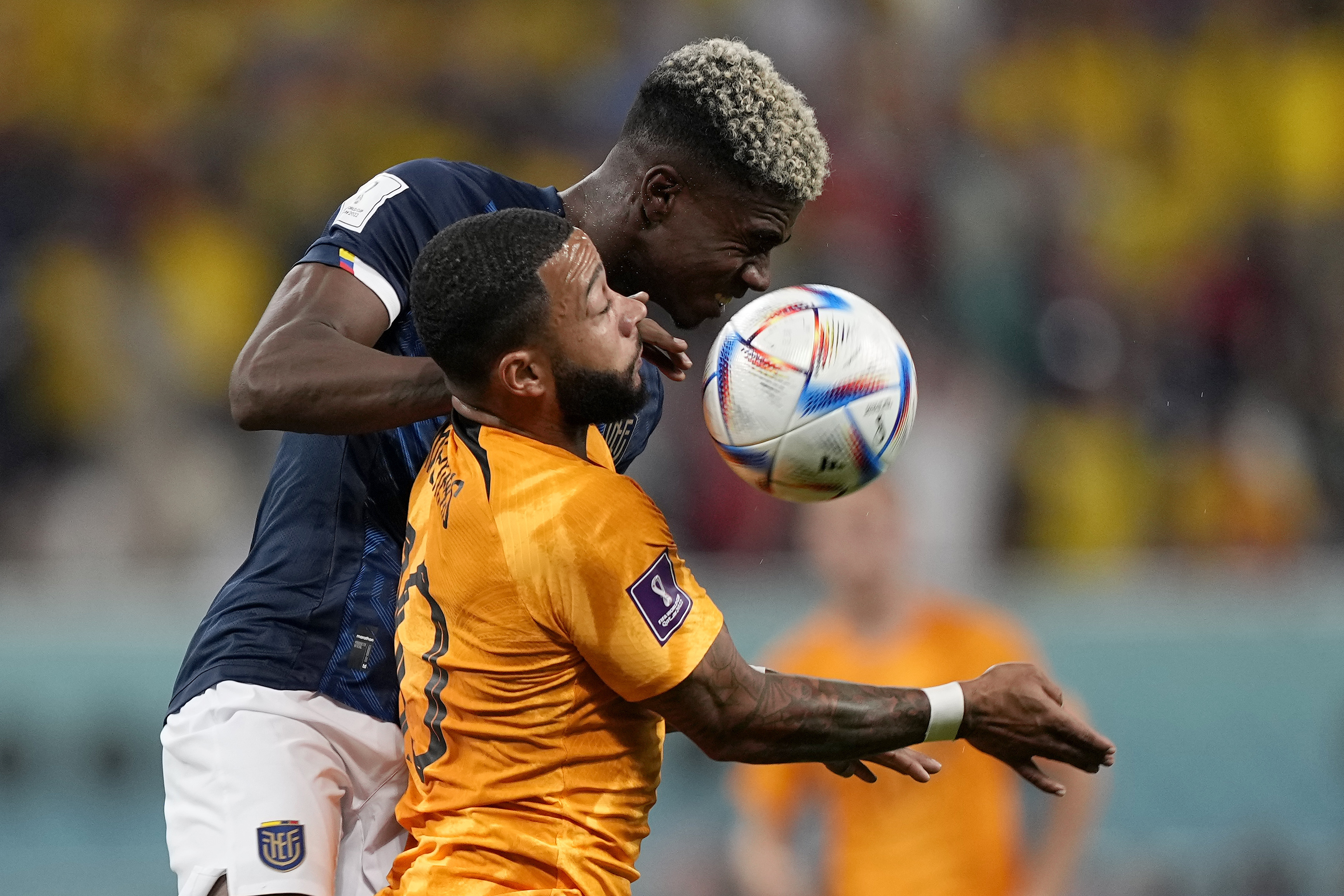 Ecuador's Felix Torres, rear, and Memphis Depay of the Netherlands challenge for the ball