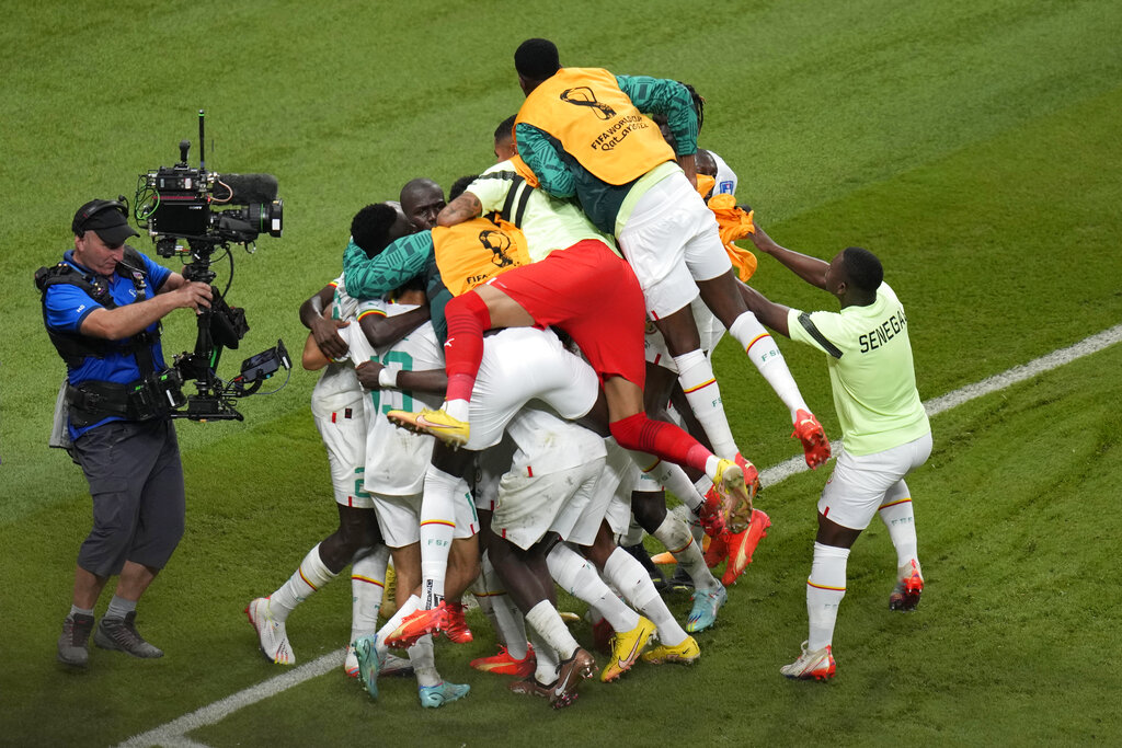 Teammates in a heap, with some having jumped onto others with joy