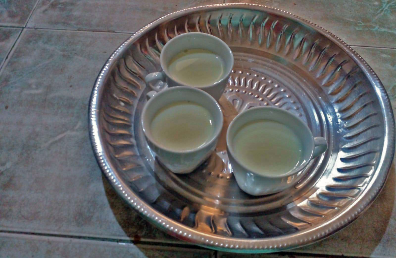 Maryam mixes a packet of milk with water to make it go further and offers it to her children