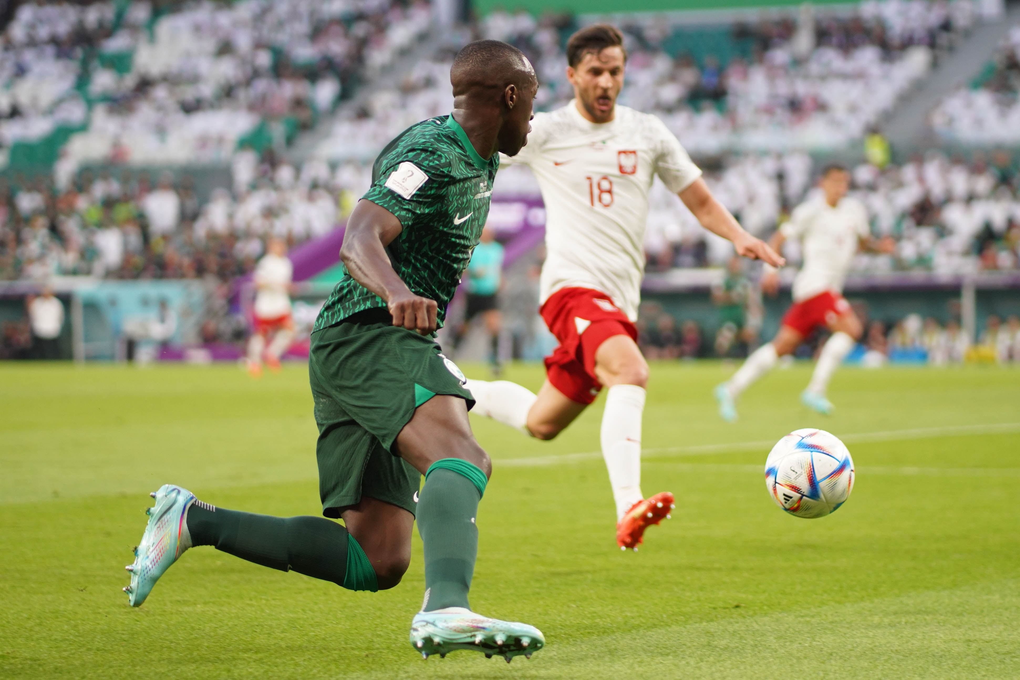 Poland and Saudi Arabia players contest for the ball.