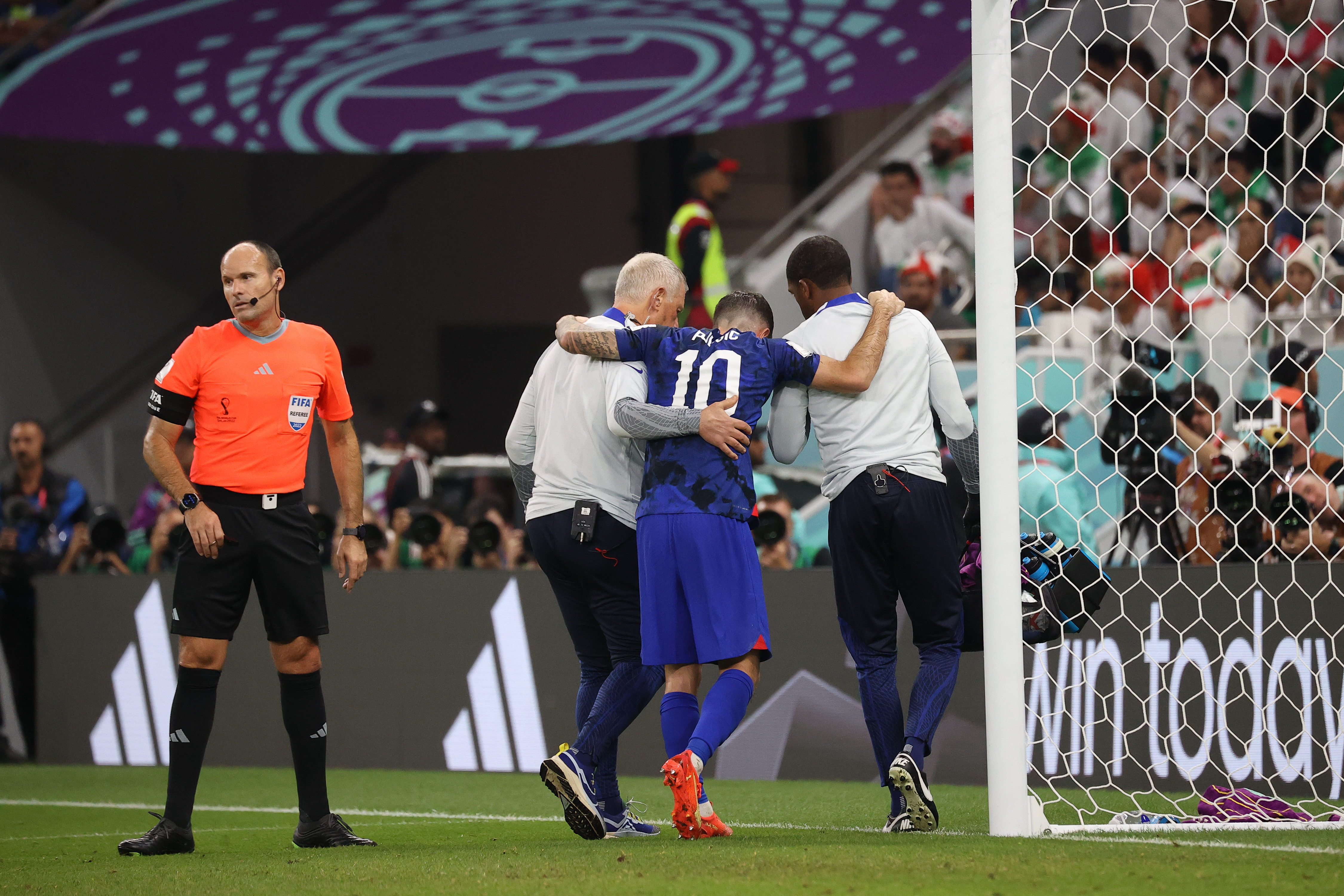 Christian Pulisic being led off the field after scoring against Iran