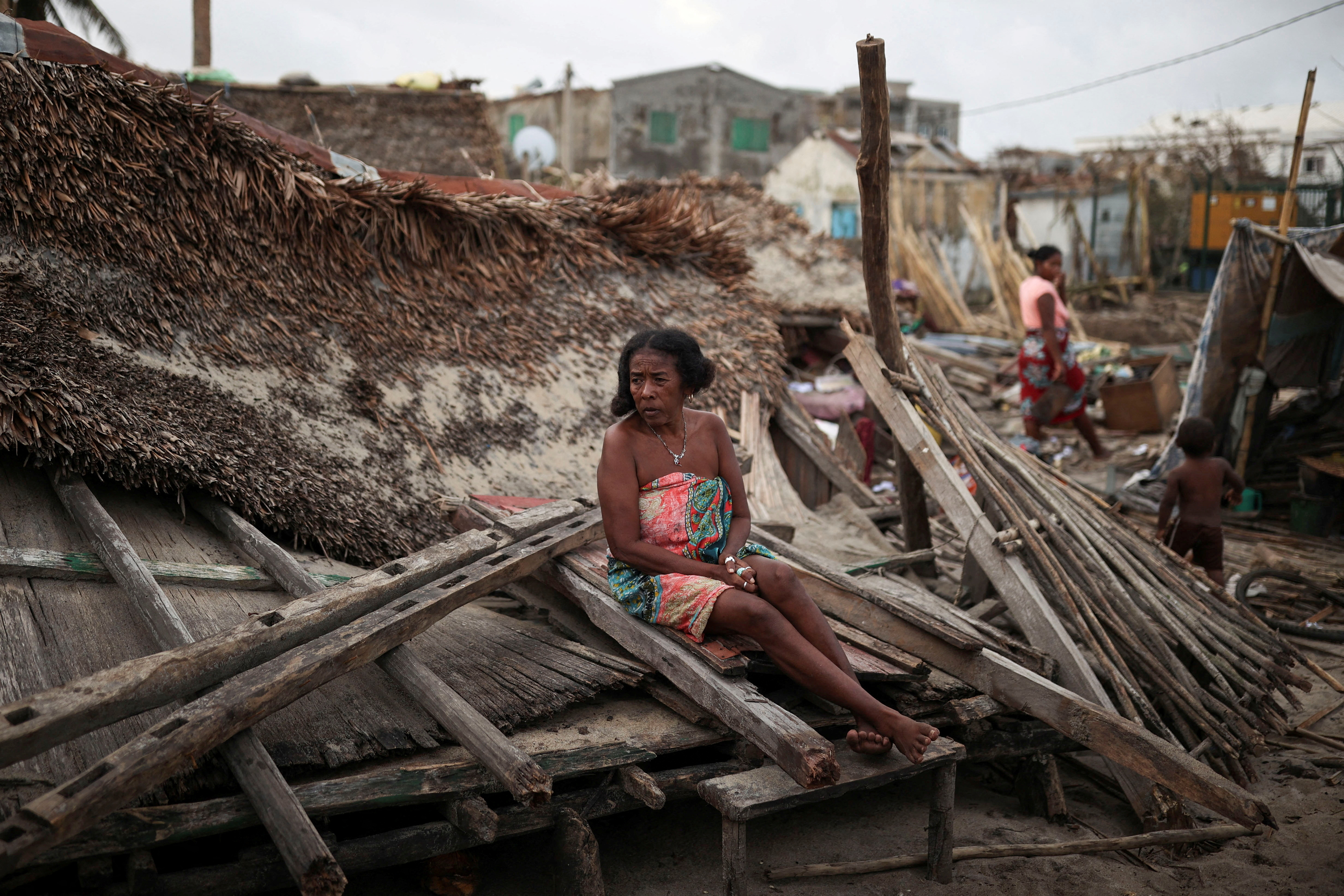 A woman sits on the debris of her destroyed house, in the aftermath of Cyclone Batsirai, in the town of Mananjary, Madagascar, February 7, 2022