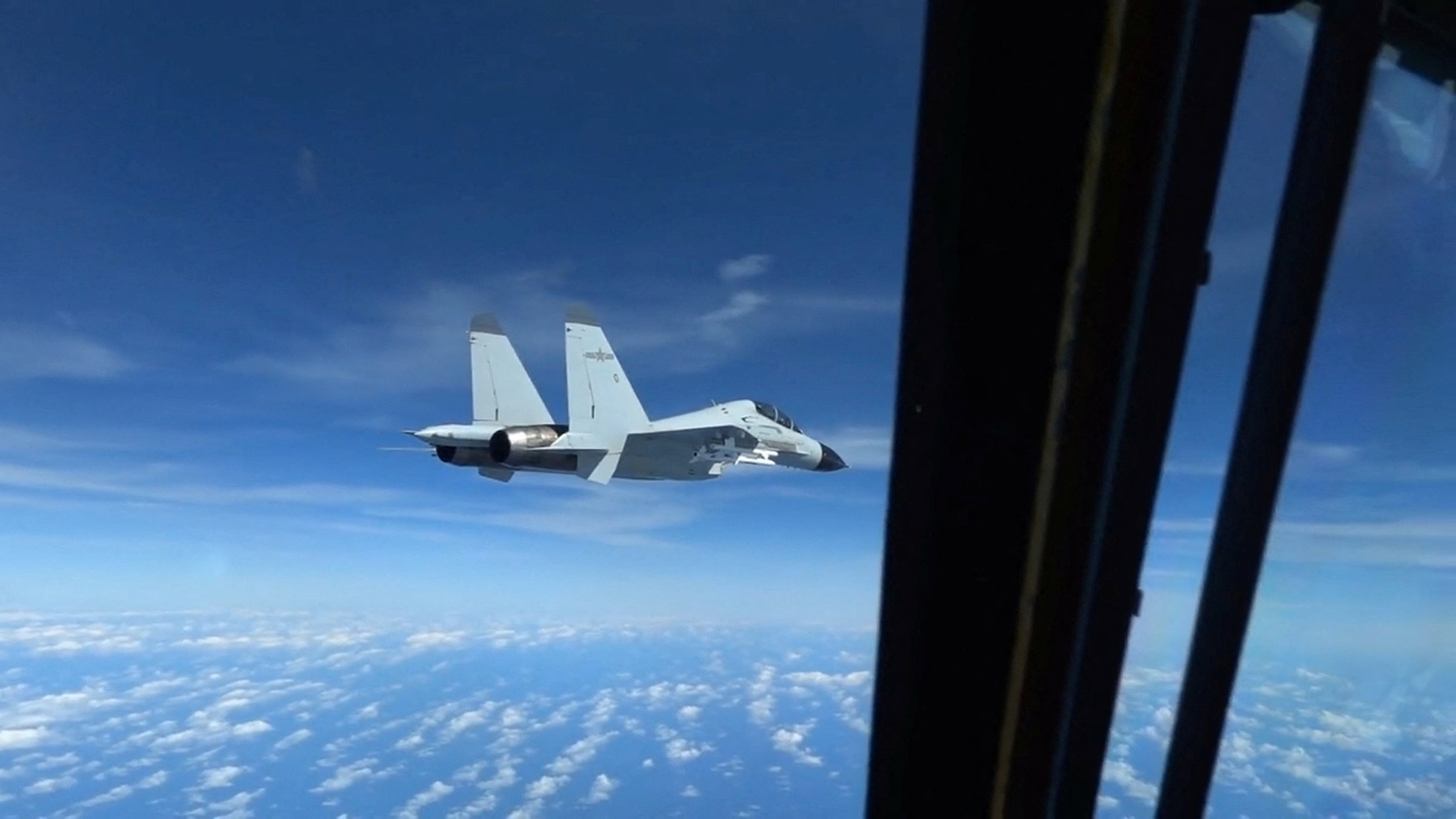 A still image from a video shot on December 21, 2022, shows a Chinese Navy J-11 fighter jet flying close to a US Air Force RC-135 aircraft in international airspace over the South China Sea.