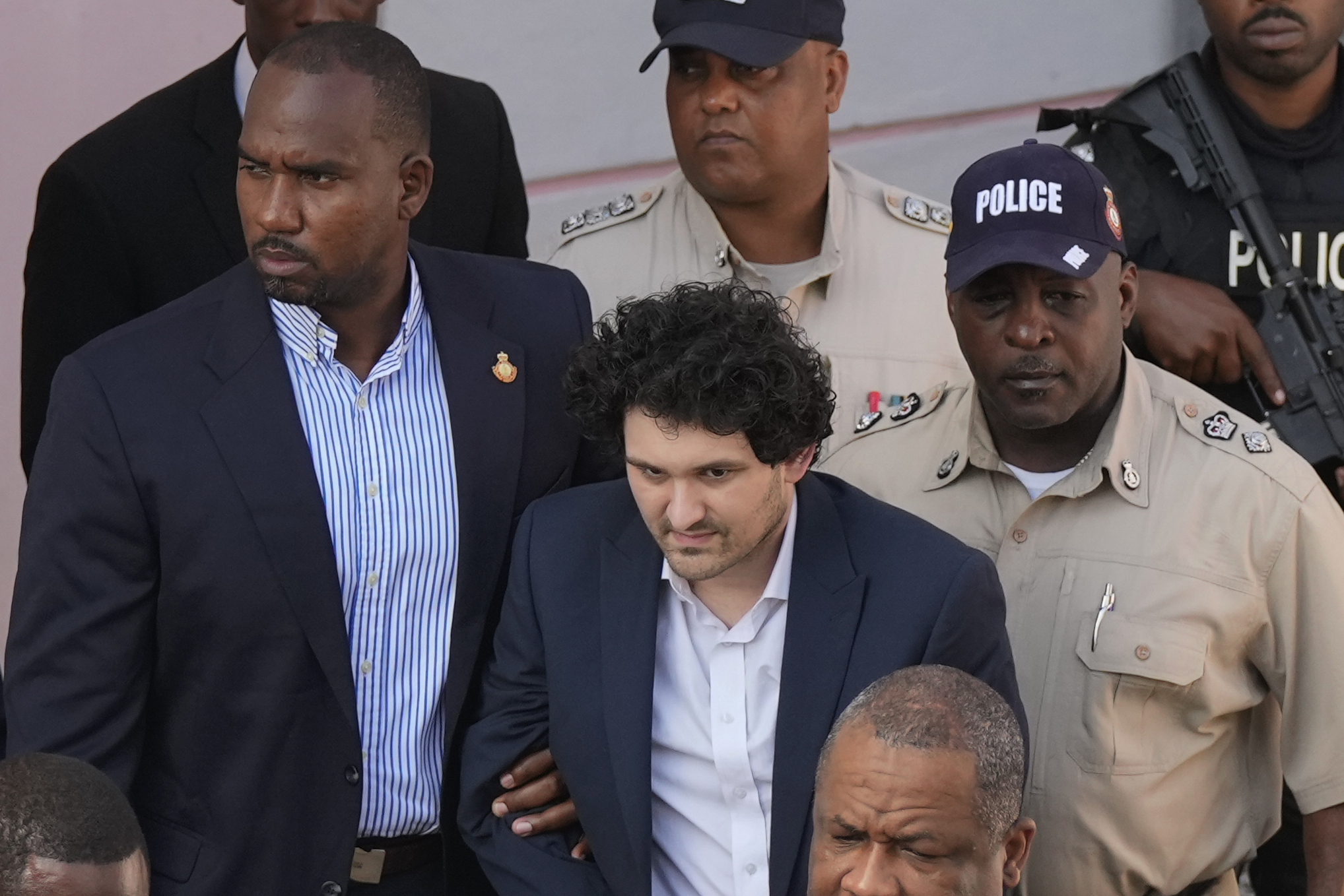 FTX founder Sam Bankman-Fried is escorted out of a court following a hearing in Nassau, Bahamas.