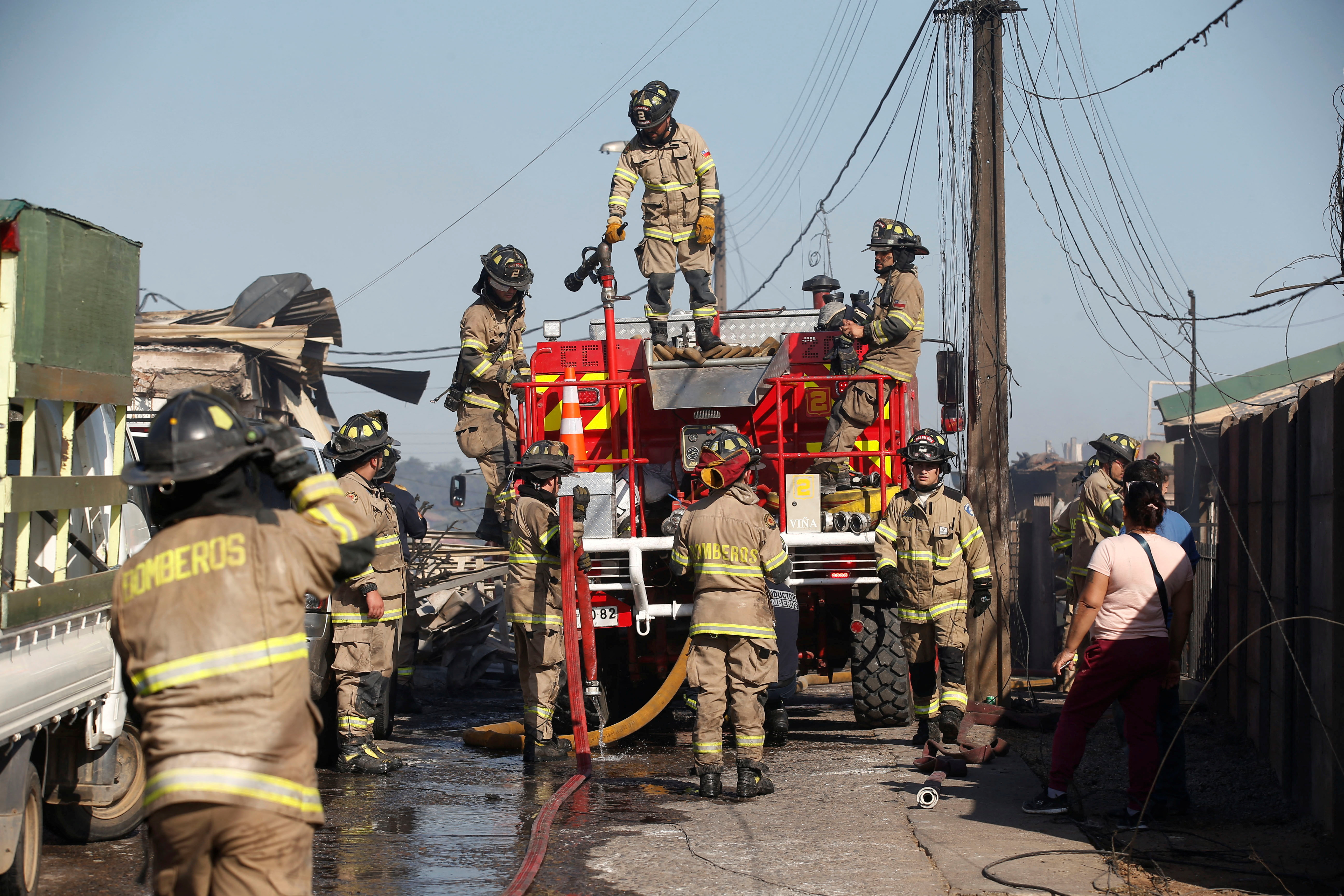 Firefires survey the remains of a burned home