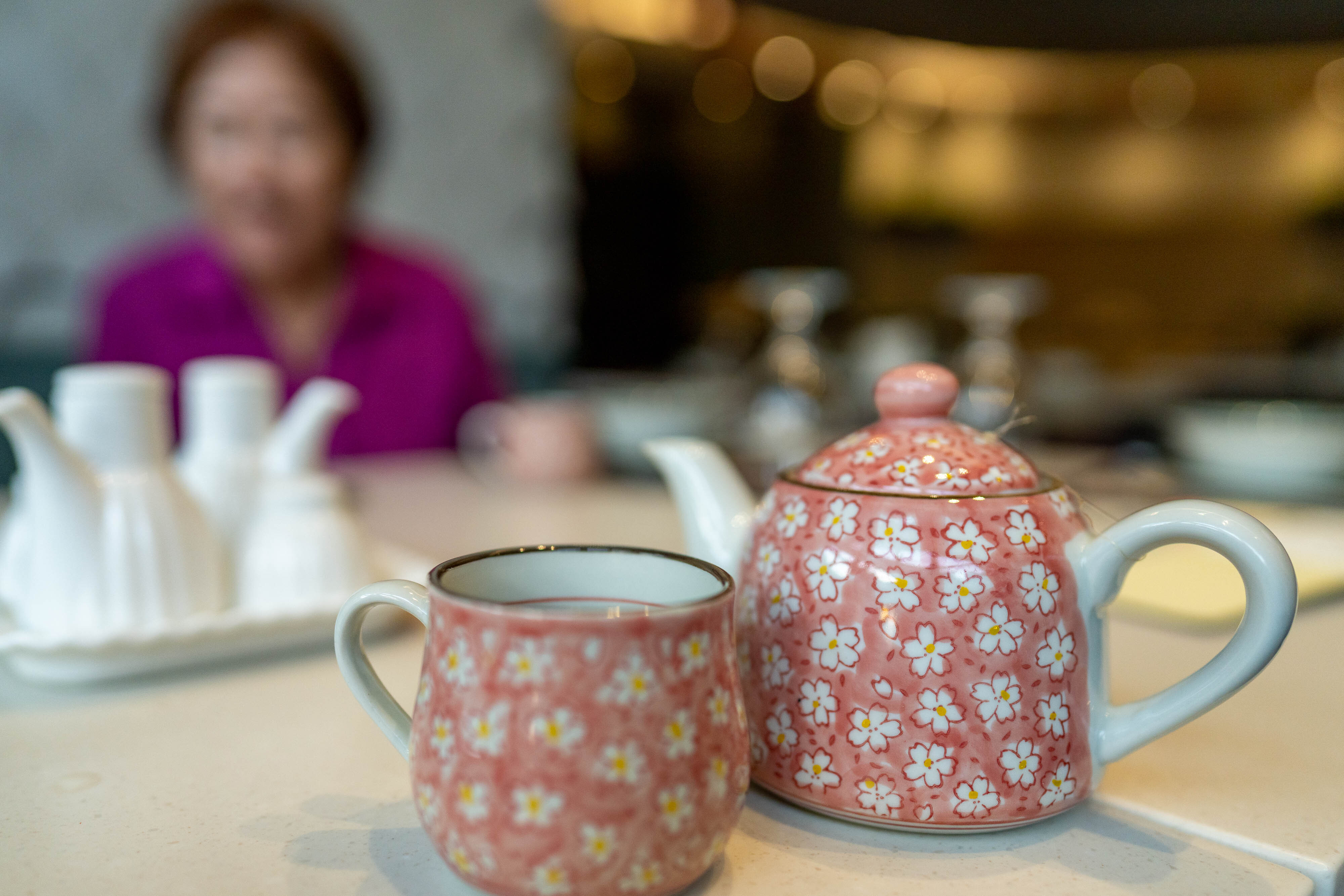 Pink teacup and teapot in the foreground, in the background is Ma Zhong Yan, slightly blurry