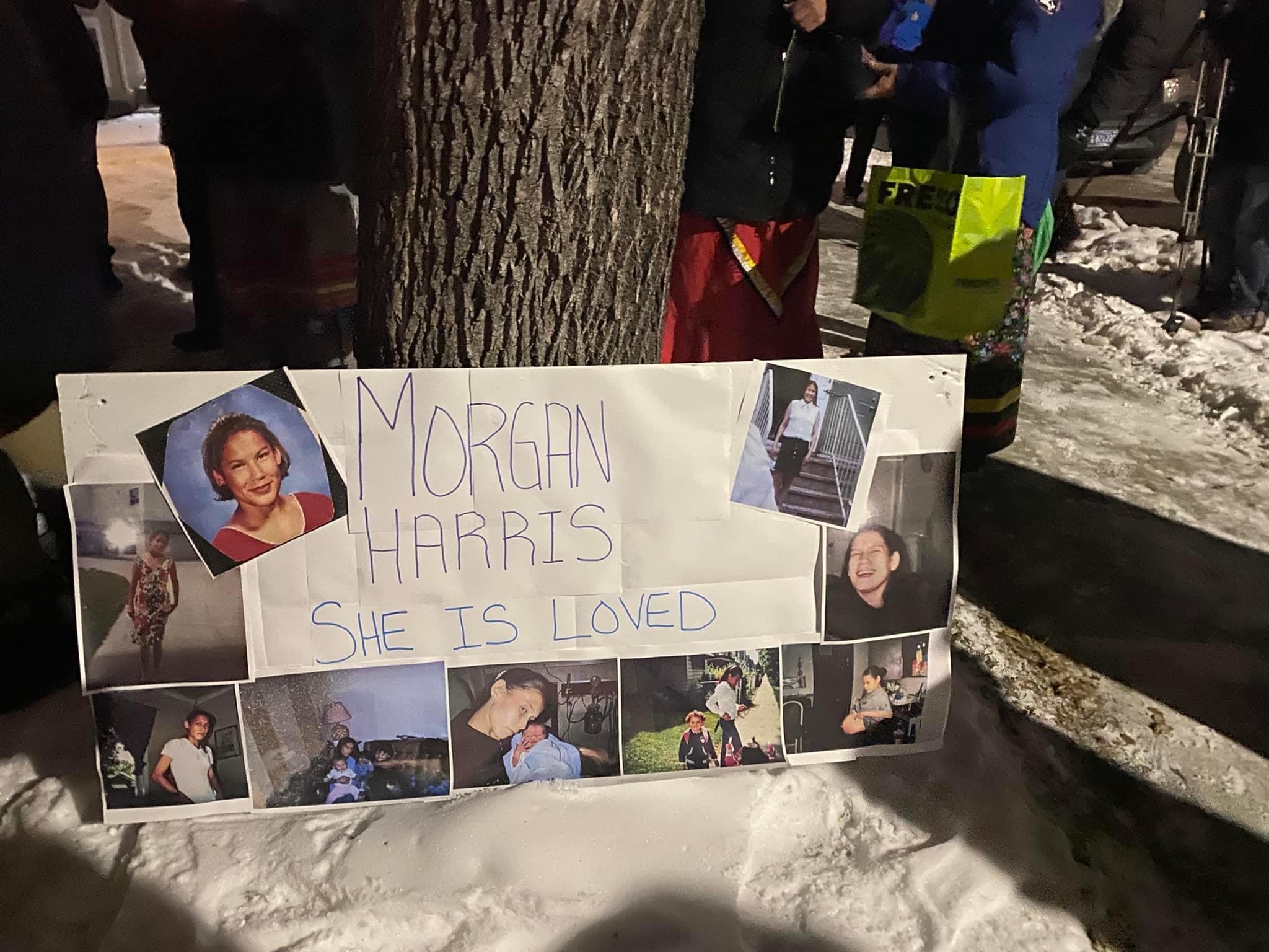 A handmade poster commemorating Morgan Harris leaning against a tree in the snow