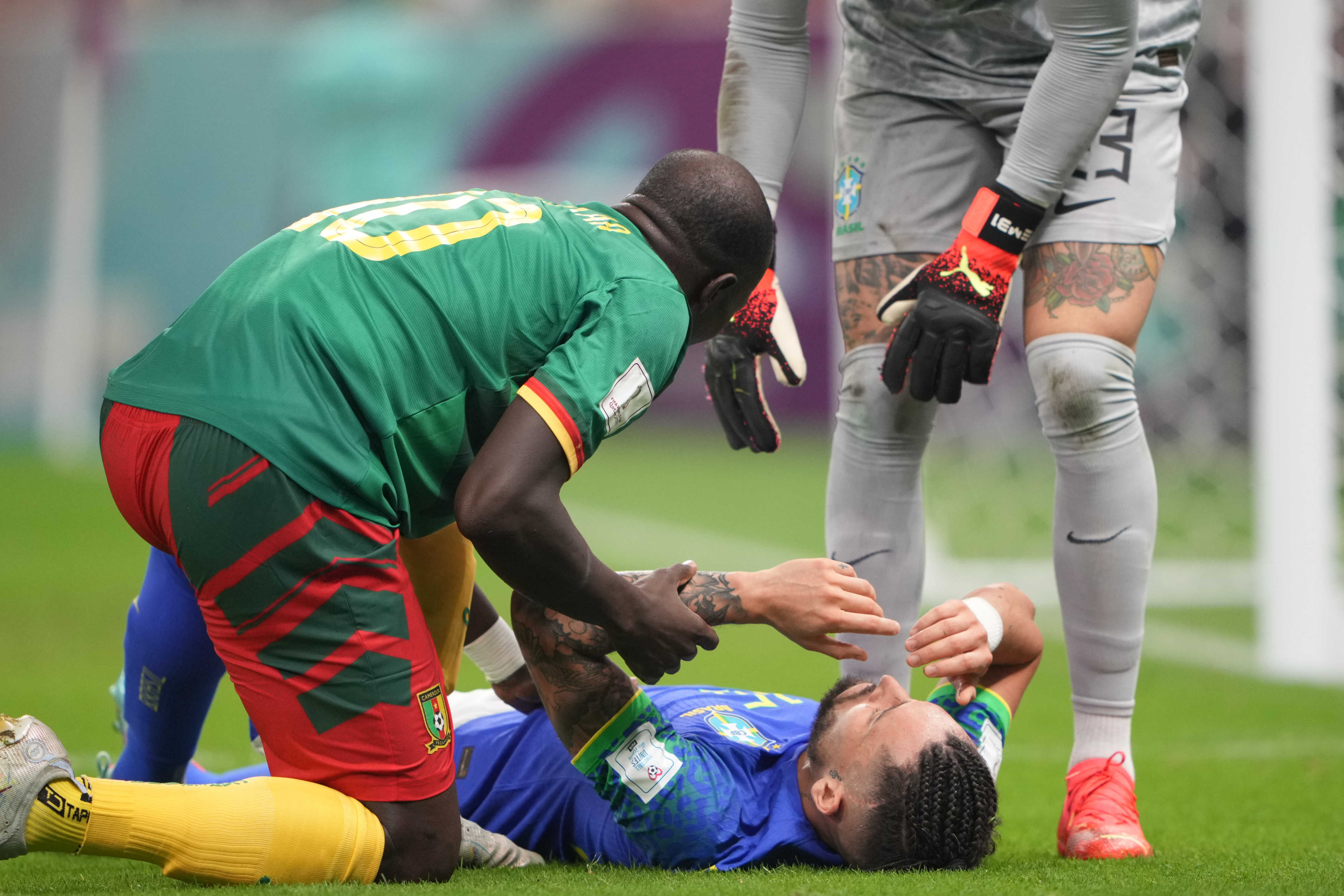 Alex Telles #16 being seen to by Cameroonian players