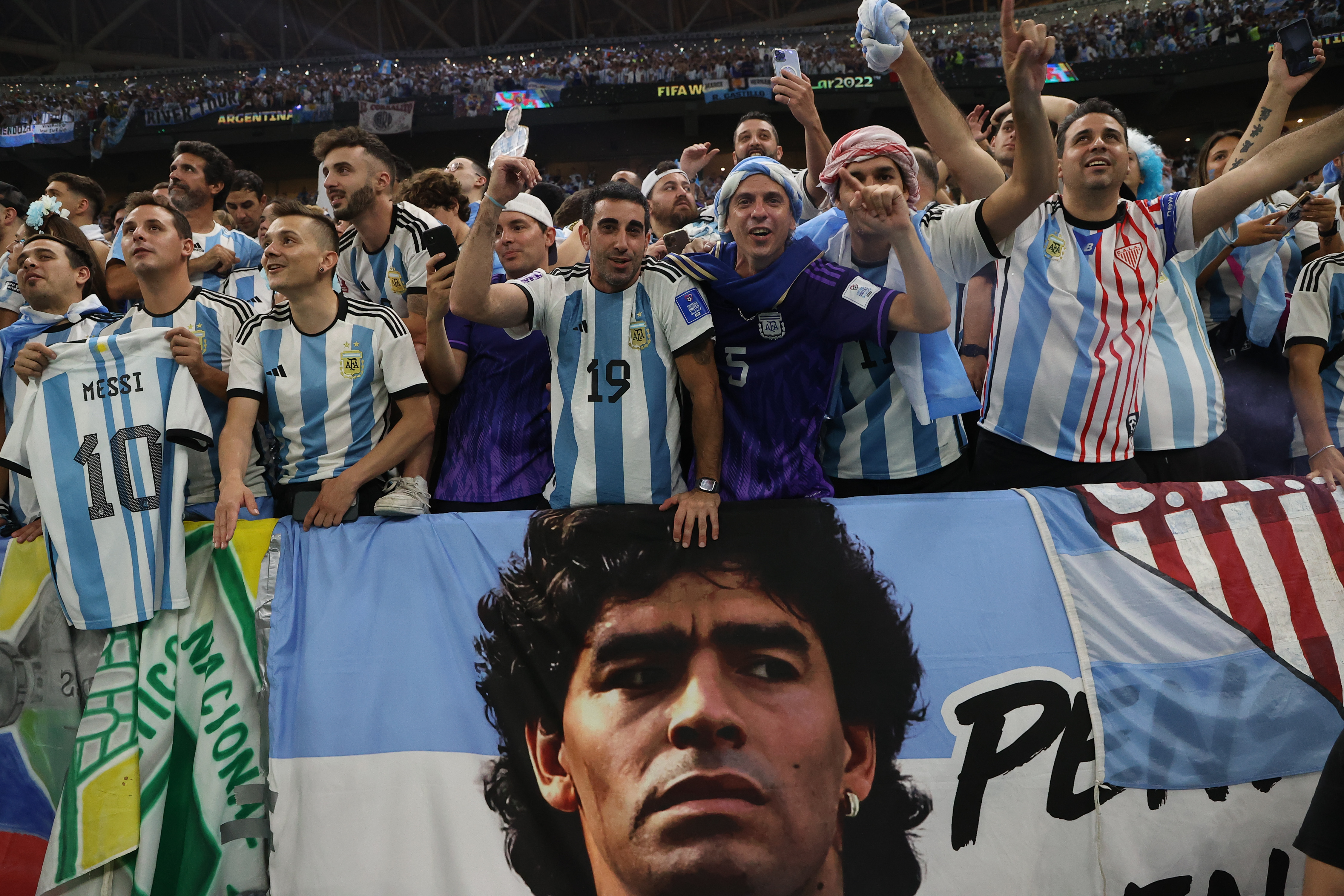 Argentina fans around a banner of Diego Maradona.