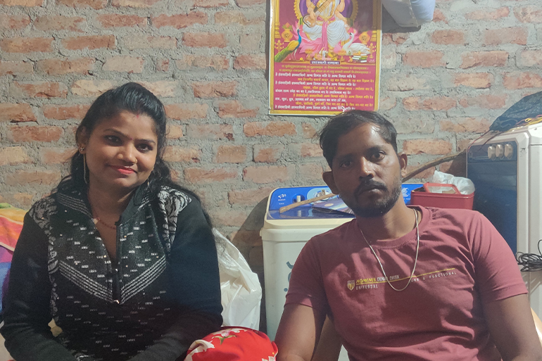 Gunja and Chand sitting next to each other and looking at the camera.