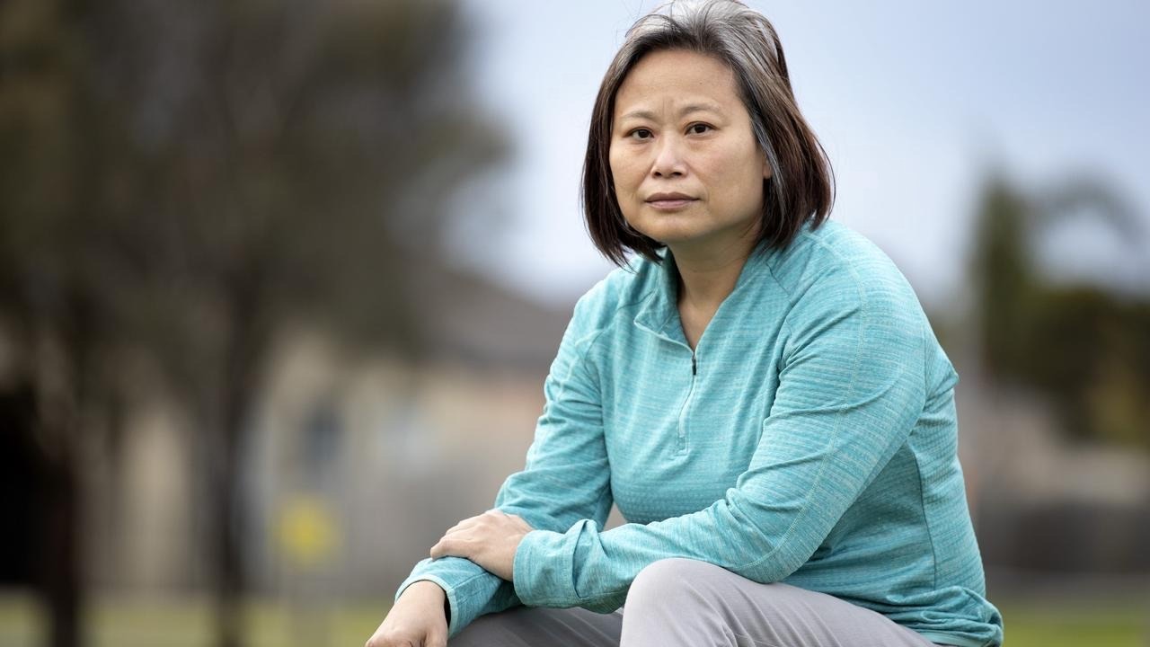 Jane Poon sitting outside and wearing an aquamarine sweater. She looks serious.