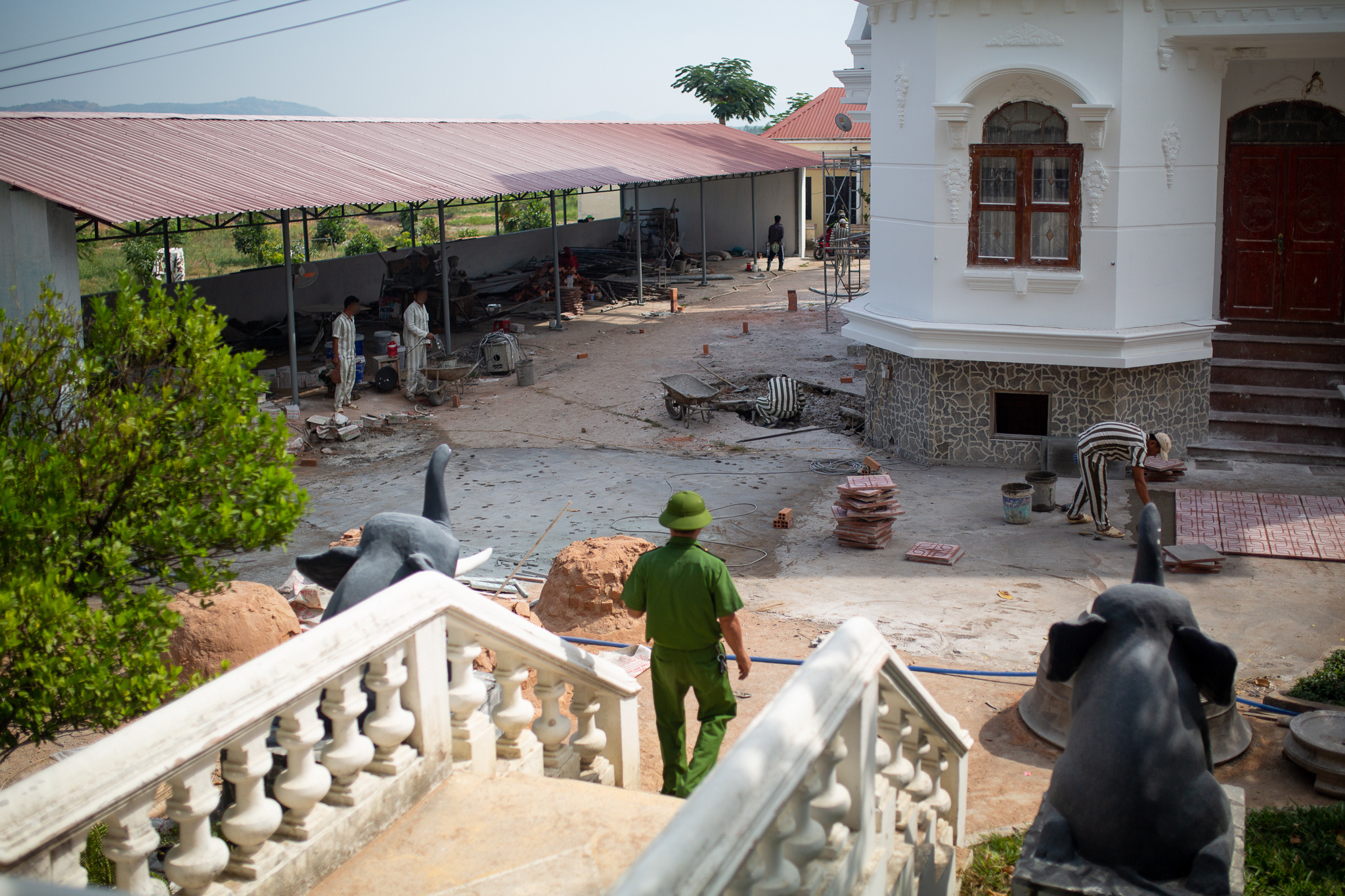 Prisoners working as construction labourers at what appears to be a cultural site