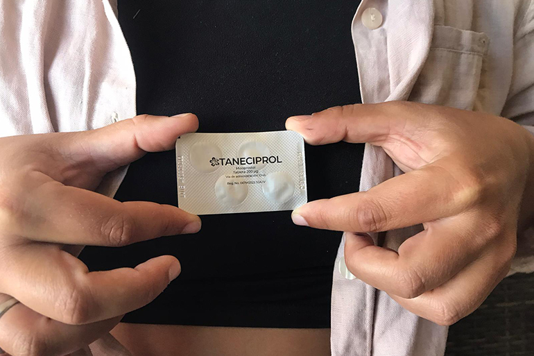 A photo of a person holding a blister pack of pills.