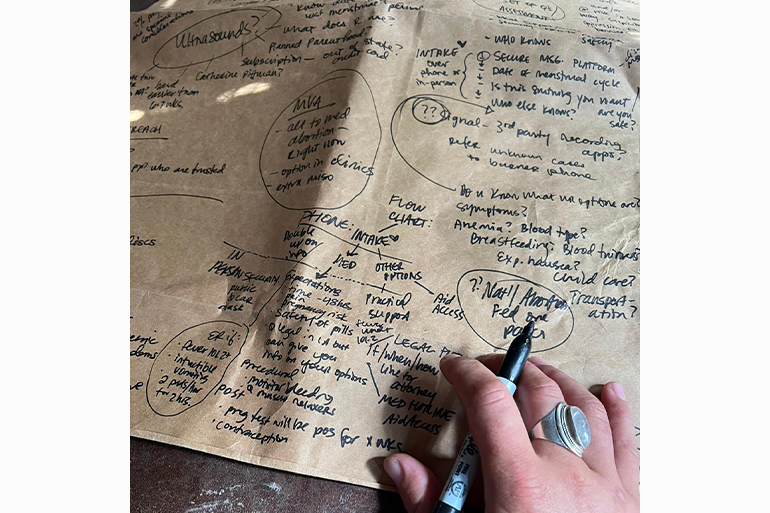 A photo of someone writing on a piece of paper.