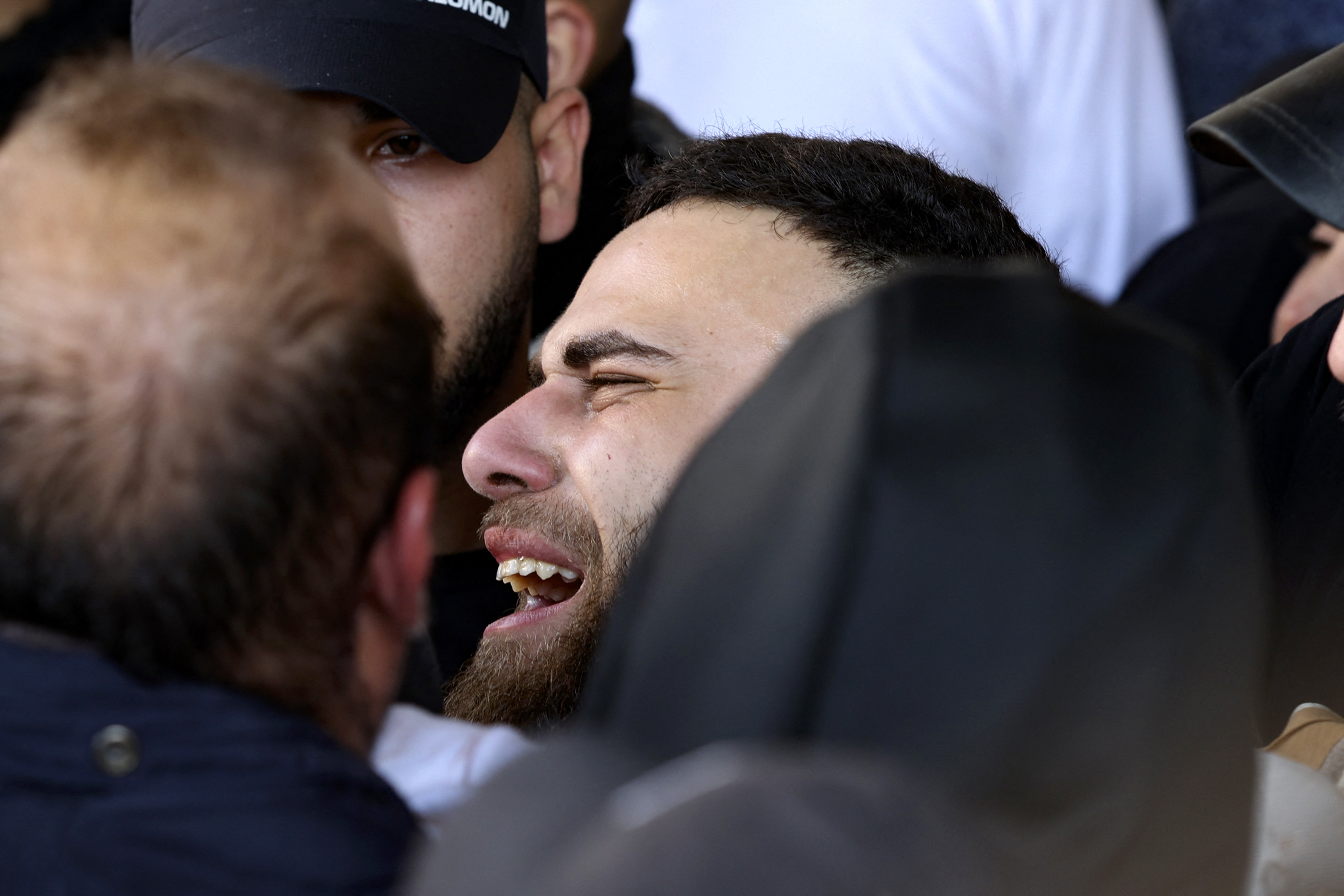 A man weeps as mourners carry the body of a Palestinian from a hospital morgue