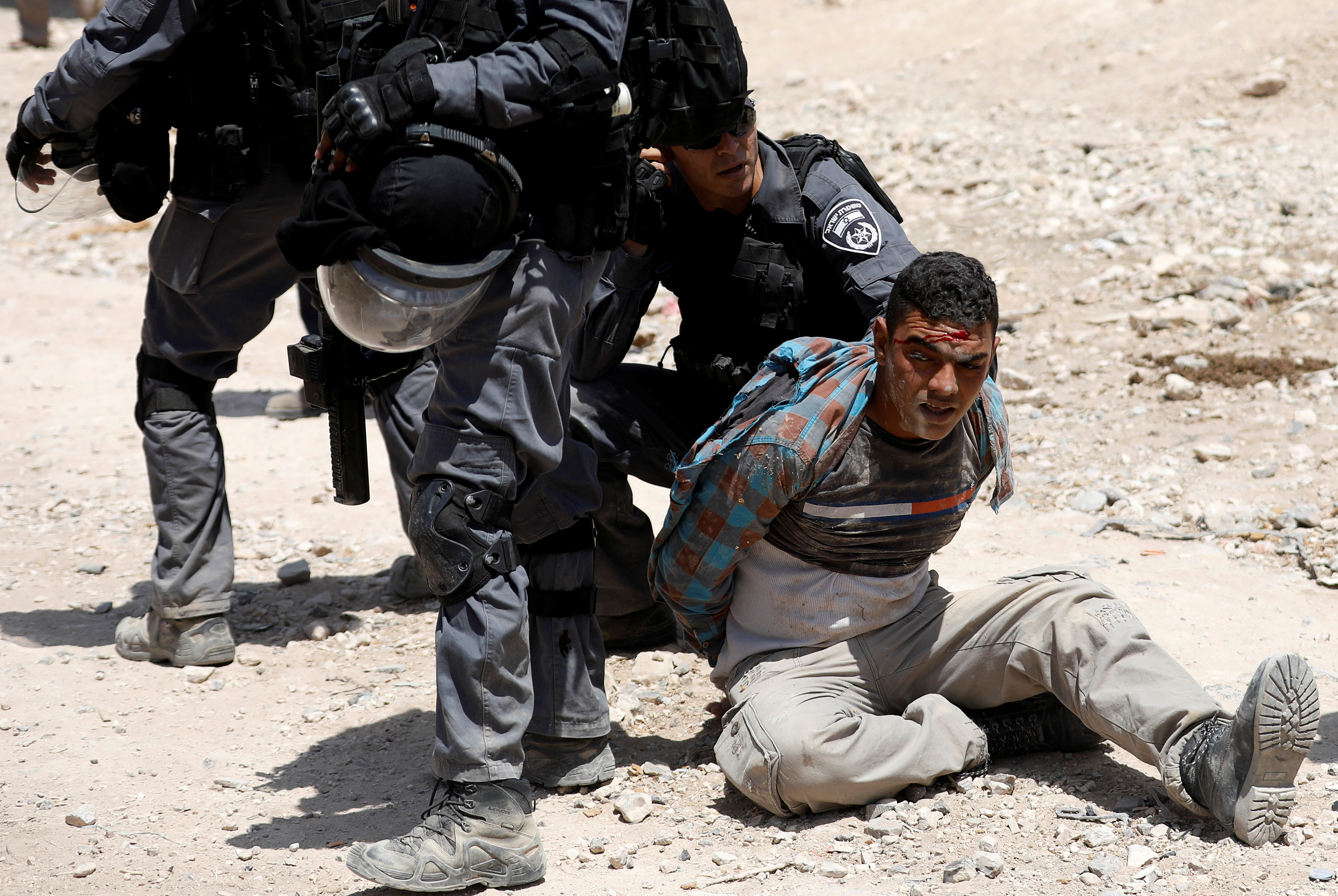 Israeli policemen detain a Palestinian in the Bedouin village of al-Khan al-Ahmar near Jericho in the occupied West Bank July 4, 2018