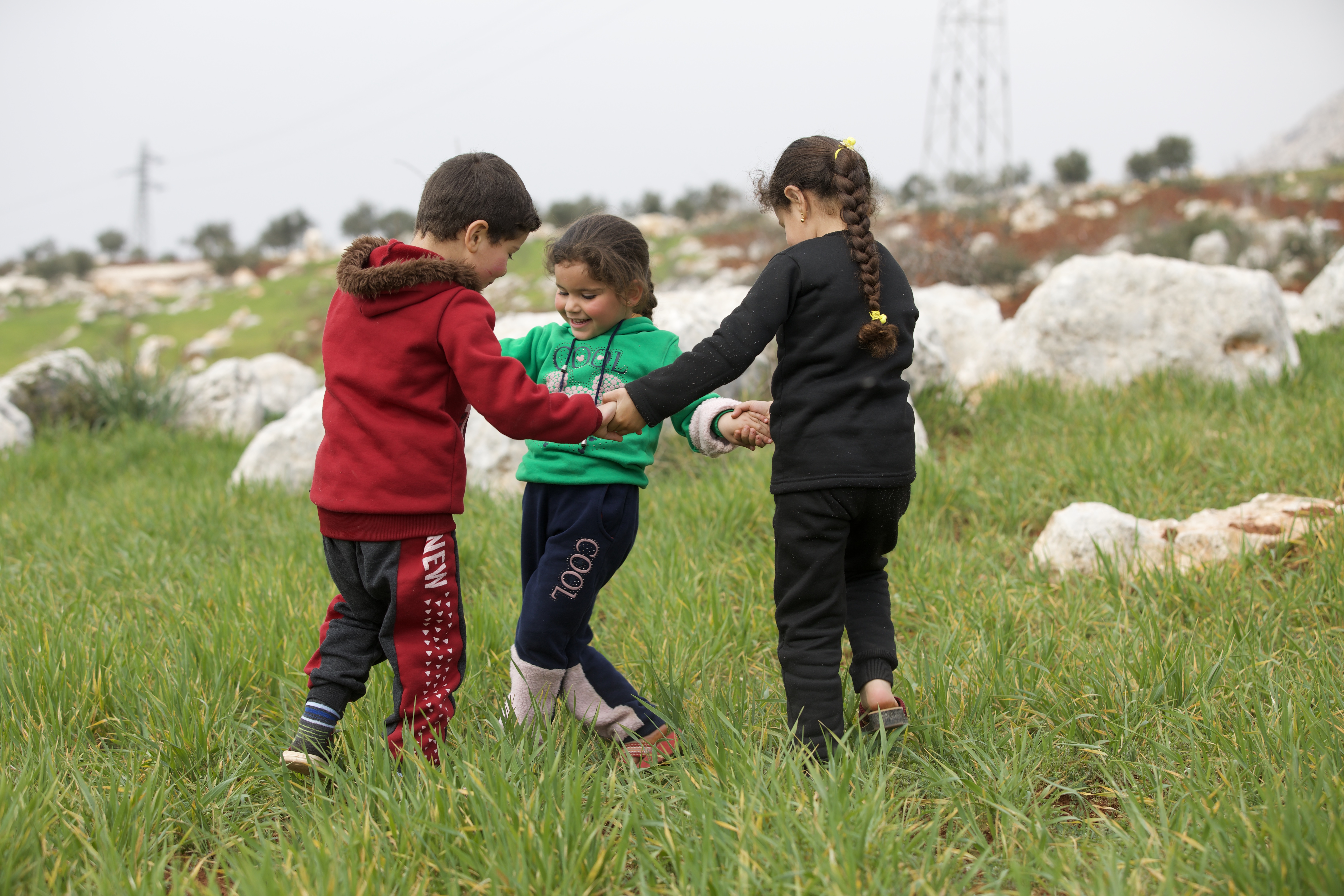Zuheir, Ilaf and Maryam al-Sayed play in a field
