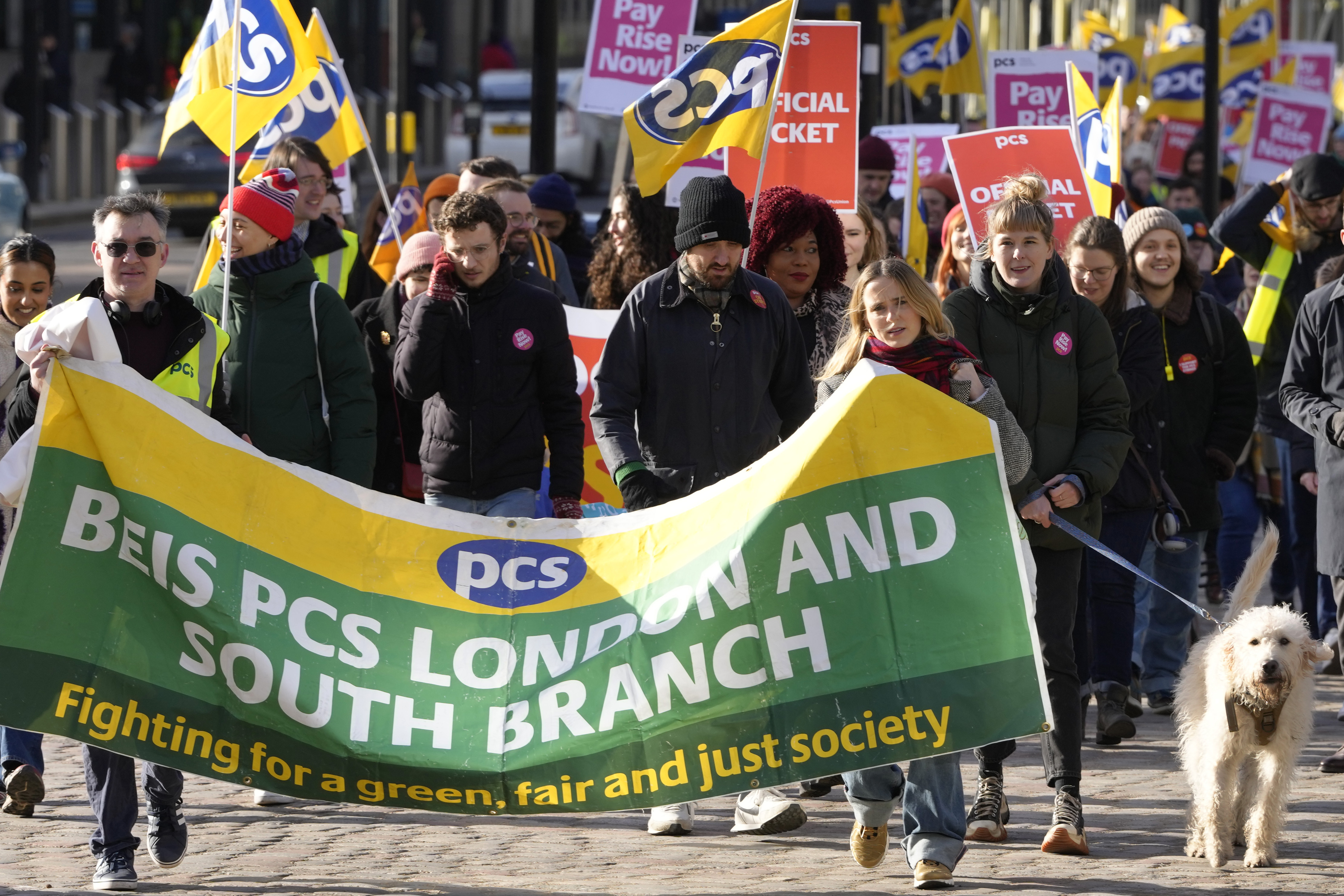 Civil servants hold banners as they protest in Westminster in London, Wednesday
