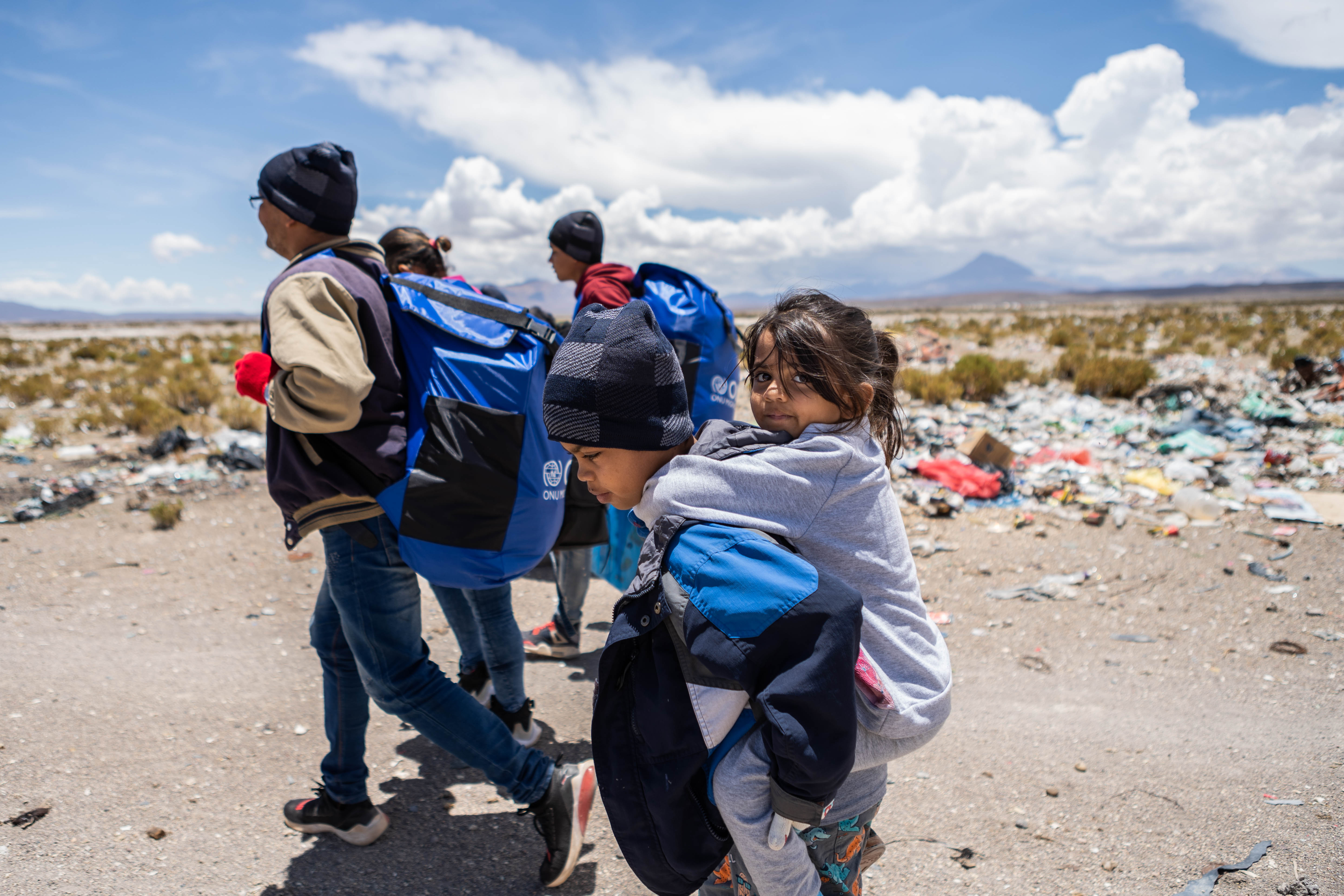 Allyson rides on the back of one of her siblings as her family makes its way across the Altiplano highlands