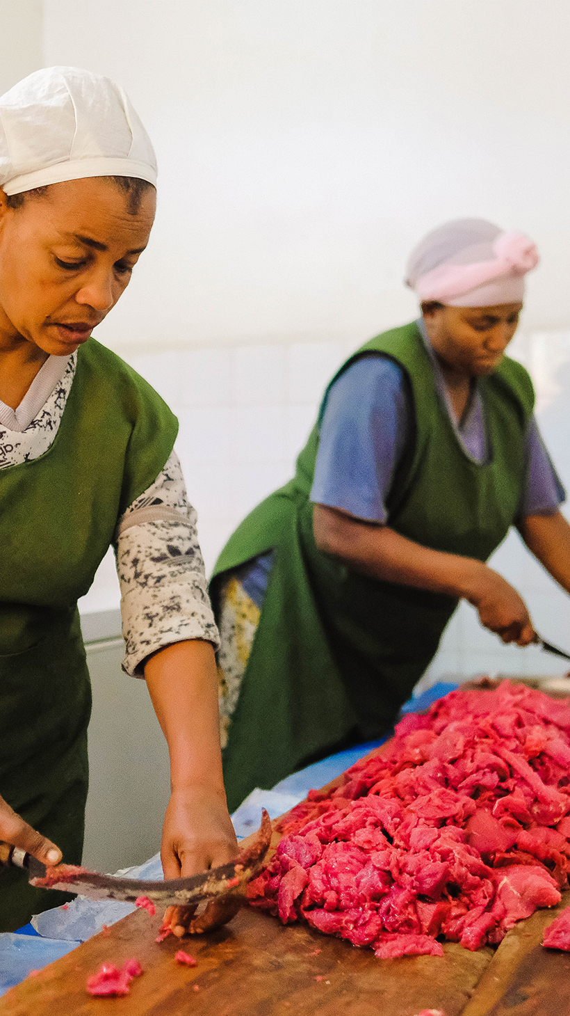 Beharia Jemal, left, and Elfenesh Gebremariam work on a mound of meat with their special, hooked lekema knives