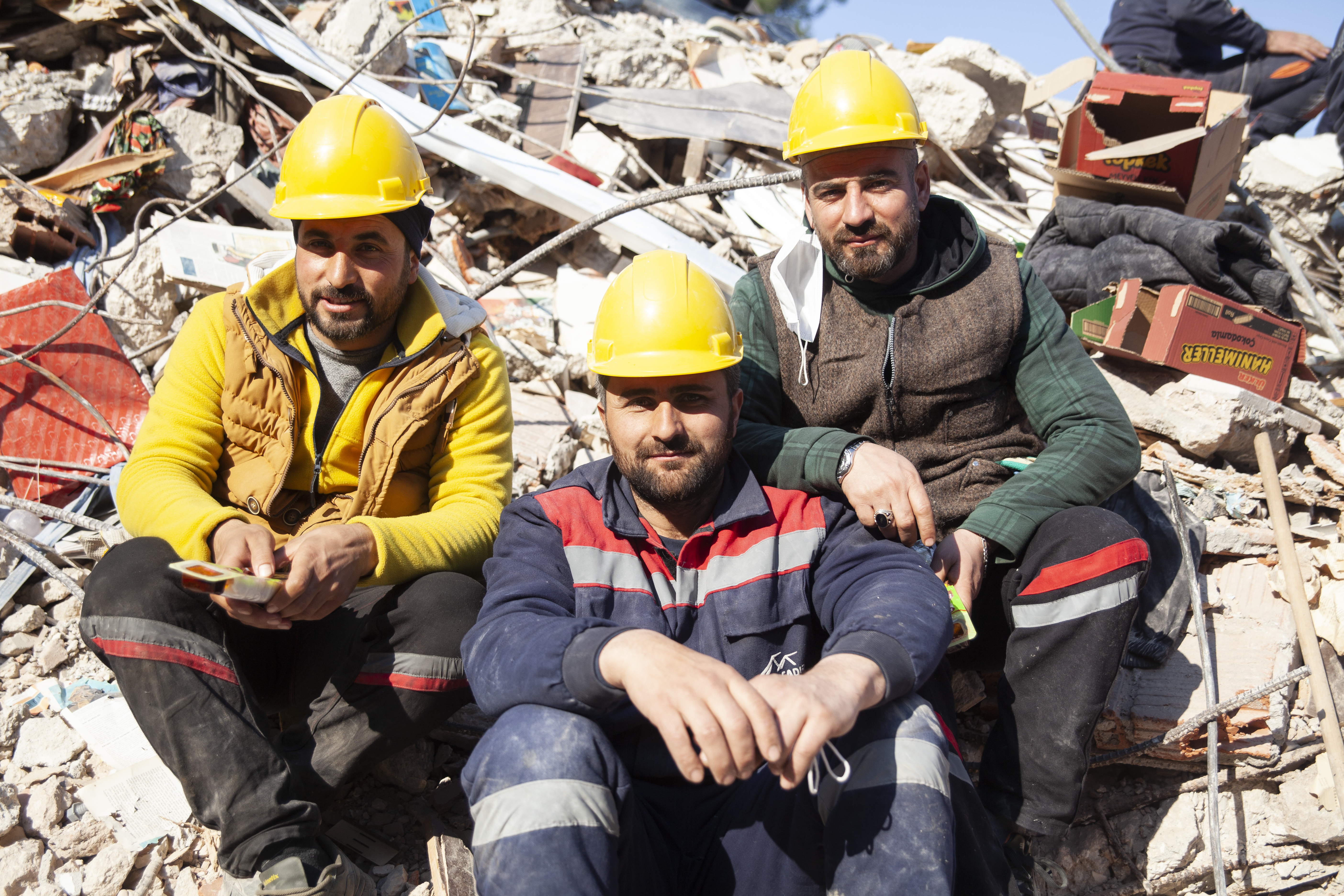 Construction workers wait to be called again in case something goes wrong under the rubble