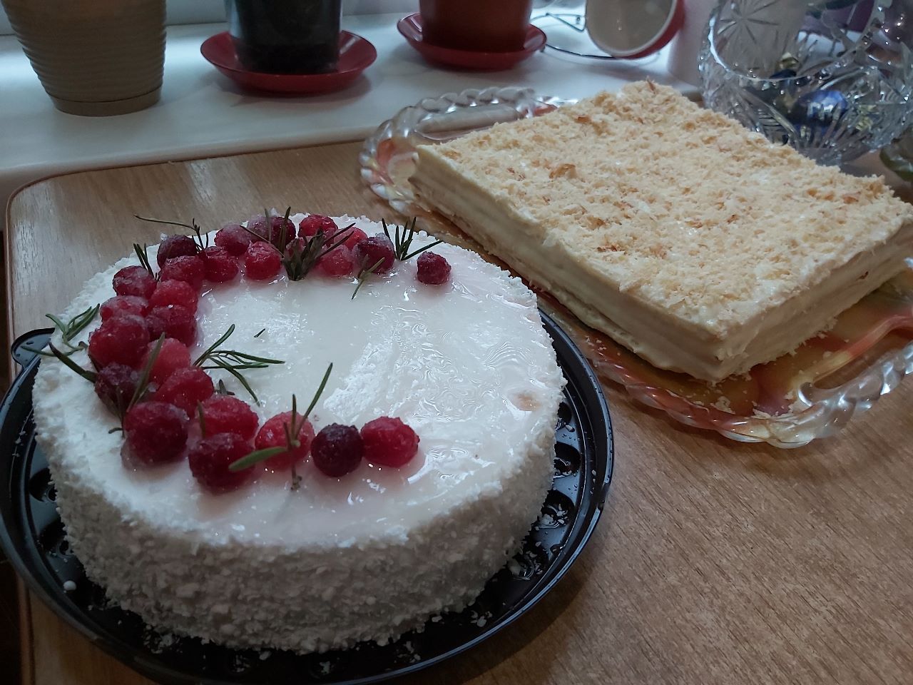 A photo of two cakes, the one on the left is round and the one on the right is a square.