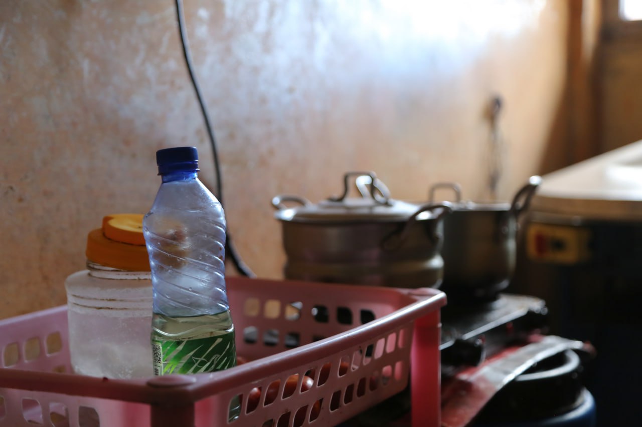 A photo of pots and pans and a bottle of water and a jar next to it.
