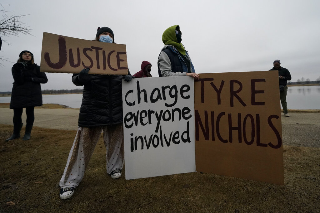 Demonstrators in Memphis hold signs calling for charges against those involved in arrest of Tyre Nichols