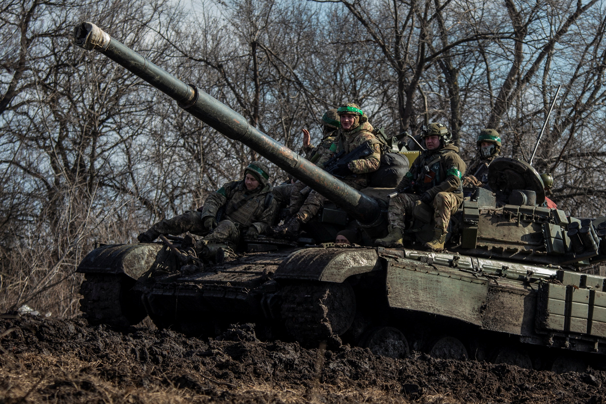 Ukrainian service members ride atop a tank outside the front-line town of Bakhmut in Donetsk region