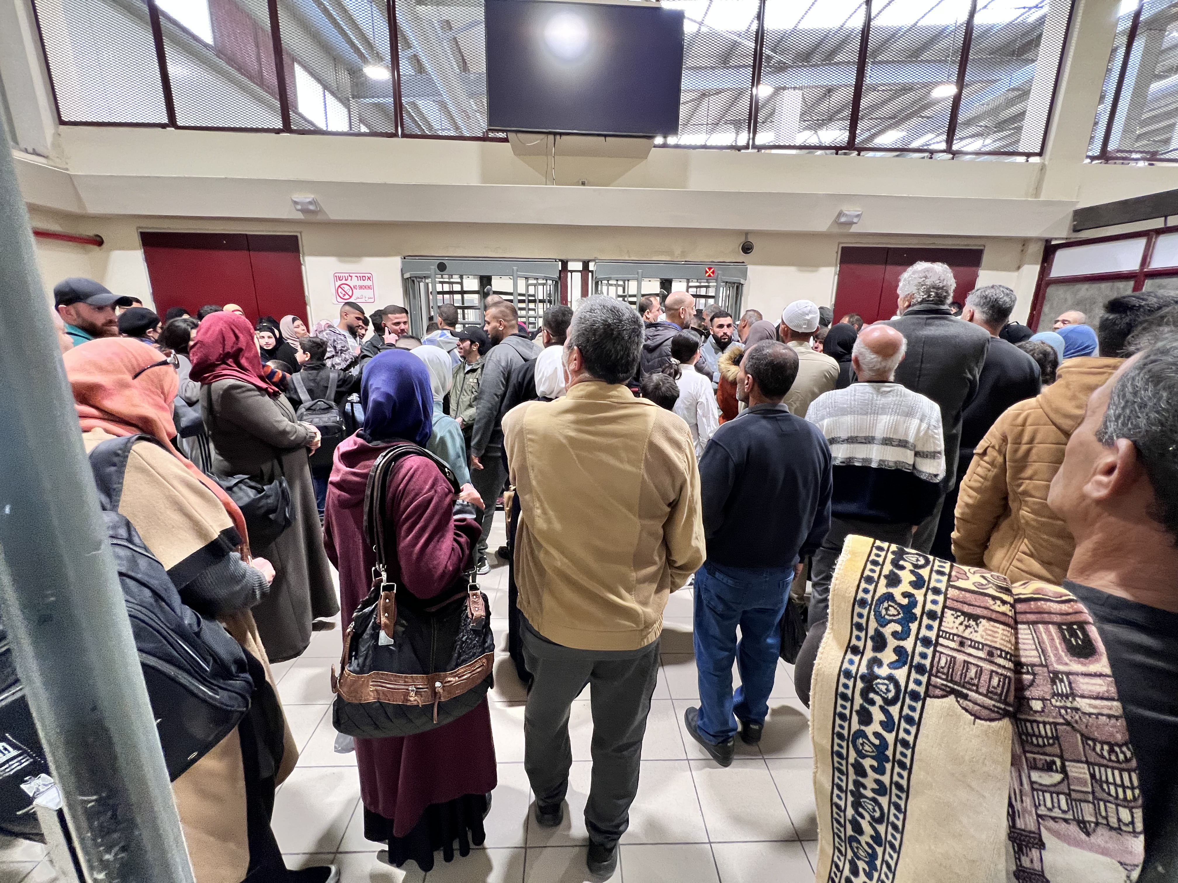 Palestinians wait to be allowed to cross Qalandiya checkpoint just north of Jerusalem