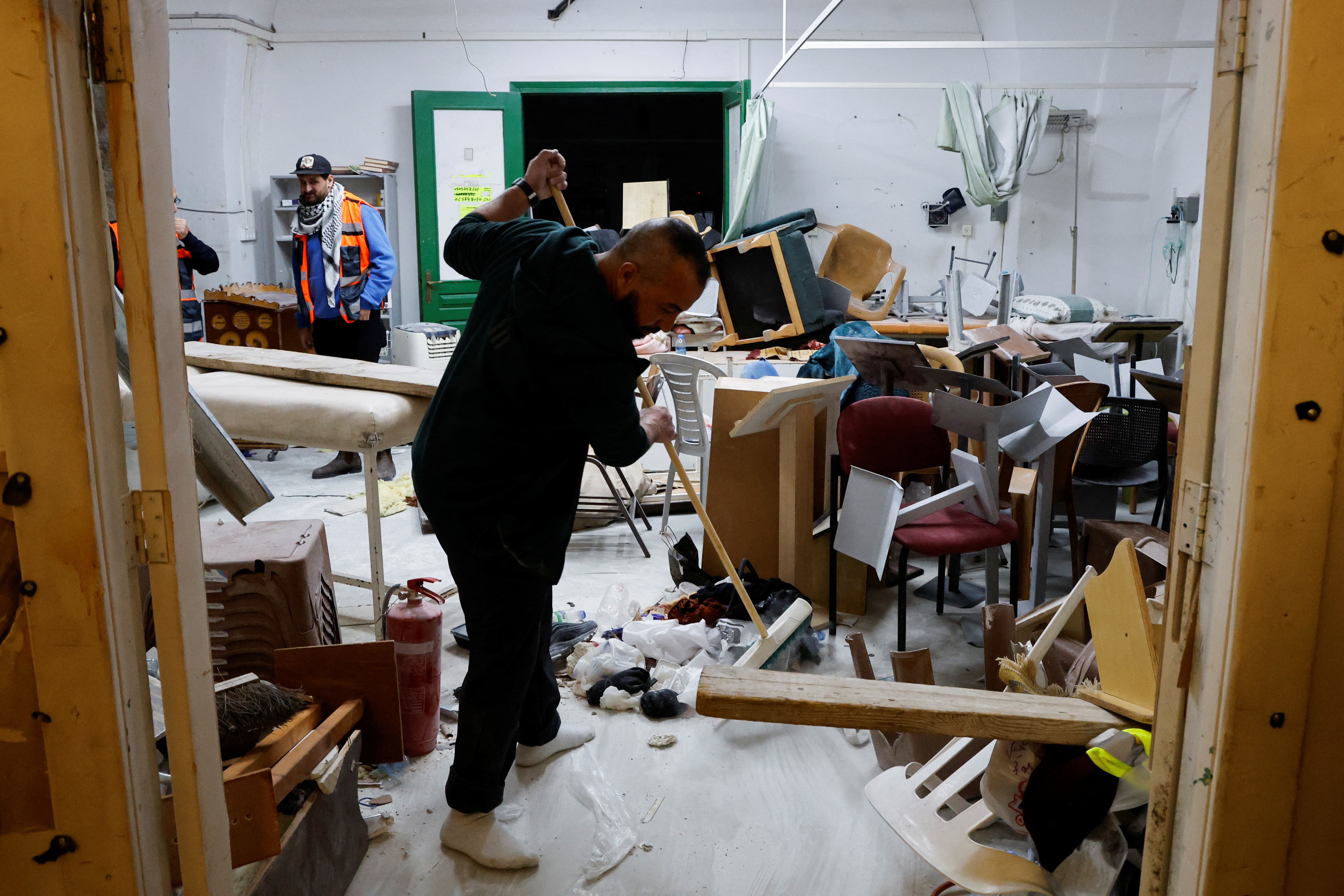 A Palestinian worshipper sweeps debris after a raid by Israeli police at the Al-Aqsa Mosque
