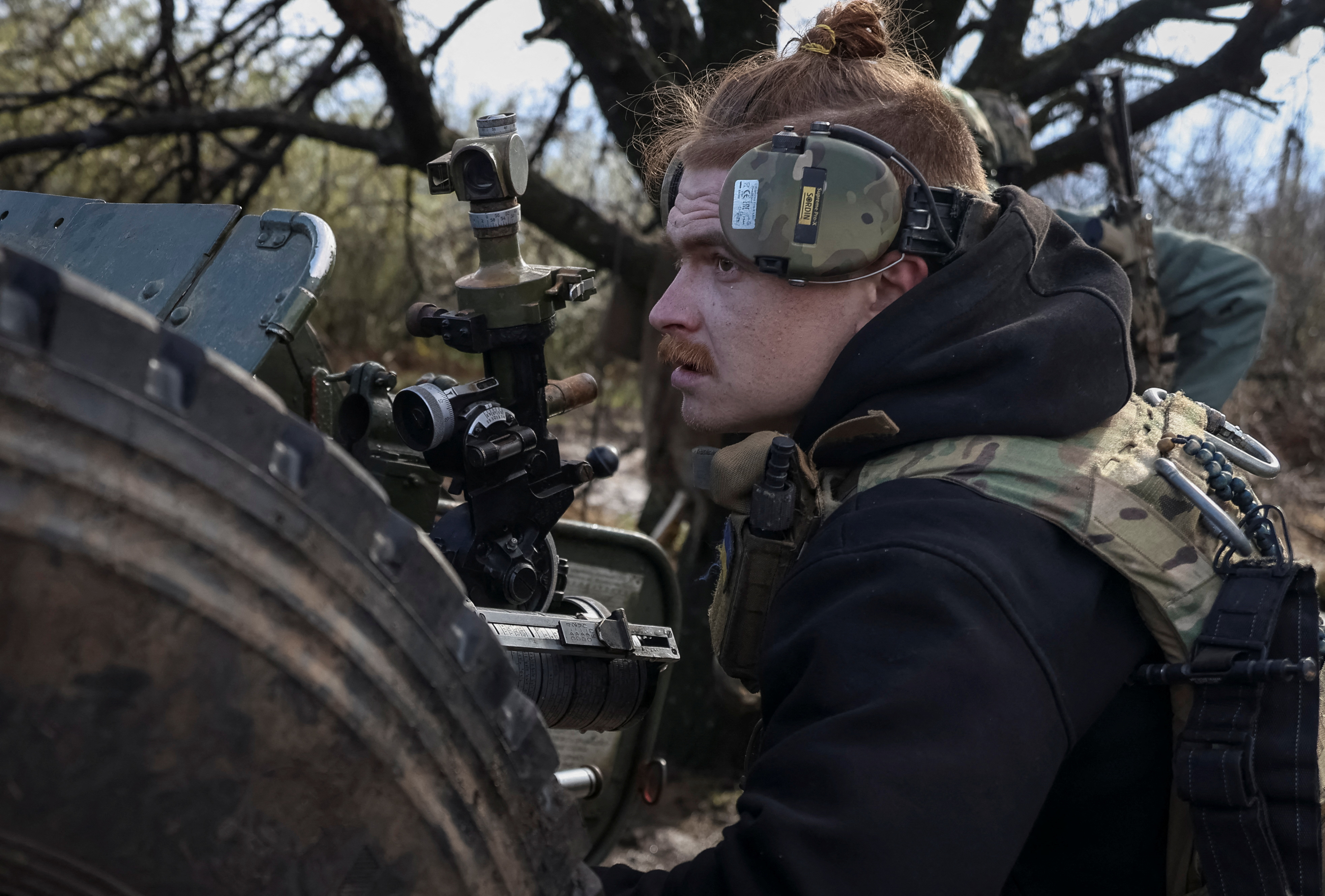 A Ukrainian soldier prepares to fire a howitzer D30 on the front line near Bakhmut