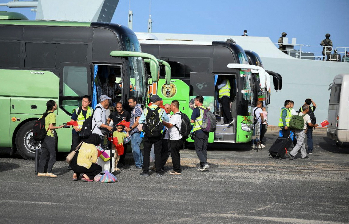 Chinese residents wait to be evacuated, as two ships are moored at the port, during clashes between the paramilitary Rapid Support Forces and the army