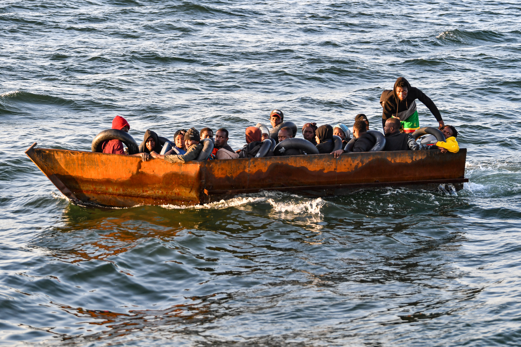 Refugees from sub-Saharan Africa sit in a makeshift boat intercepted by Tunisian authorities about 50 nautical miles in the Mediterranean sea off the coast of the city of Sfax.